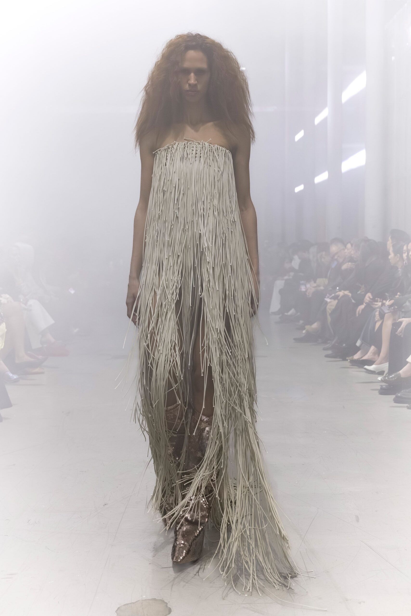 beige fringed strapless gown with gold boots