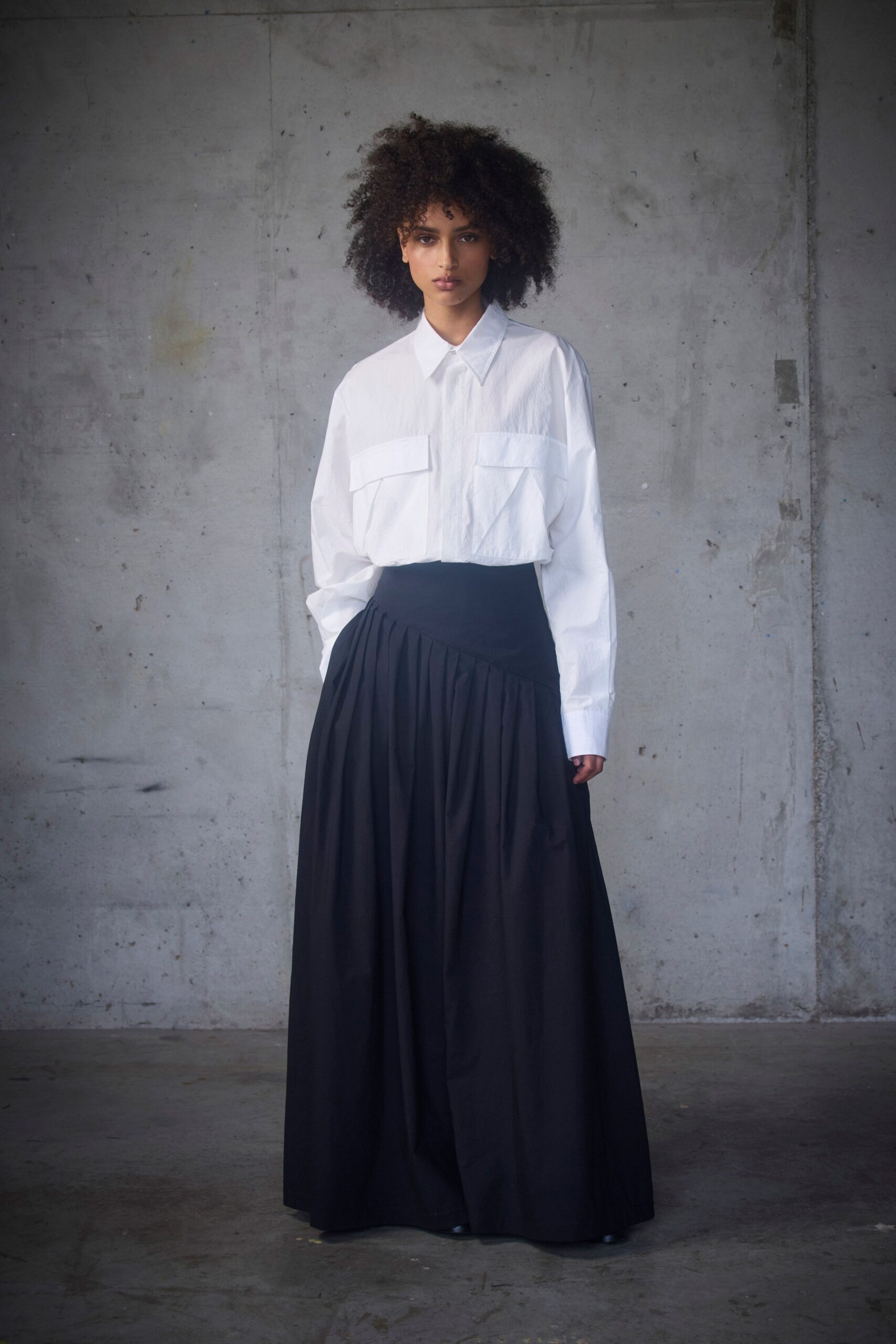 white relaxed shirt with black pleated skirt