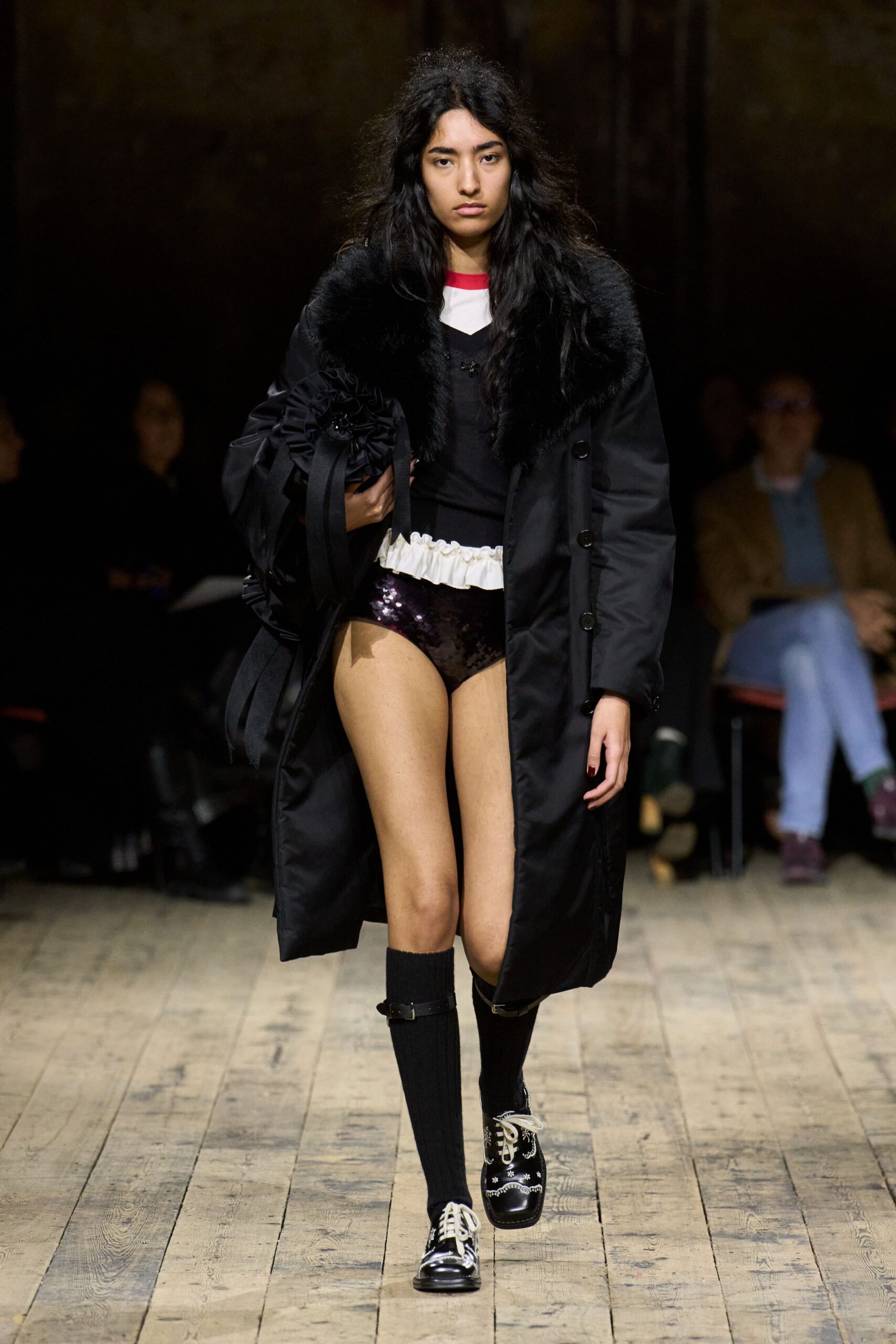 black faux-fur coat with purple shorts