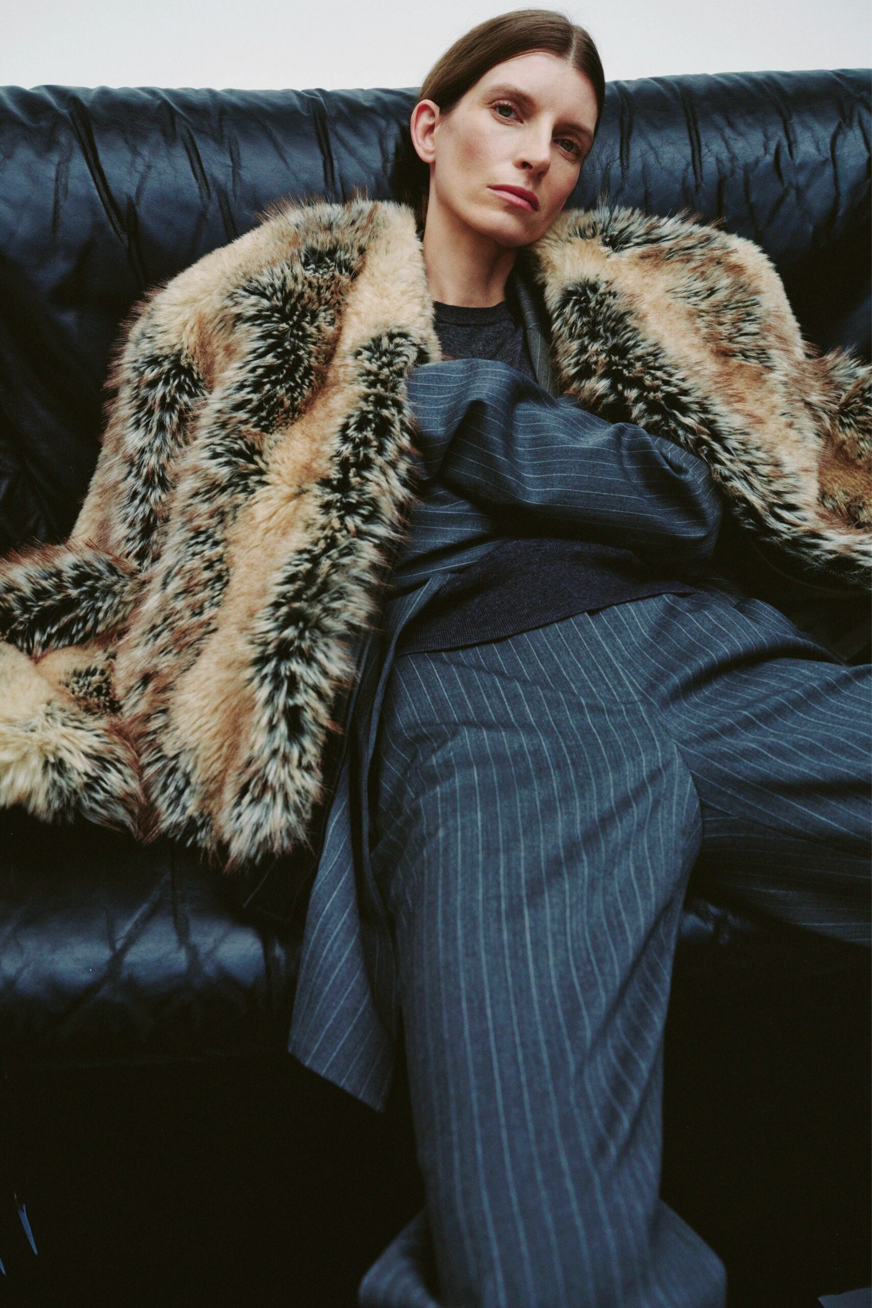 gray wool relaxed pants with black top and fur cape