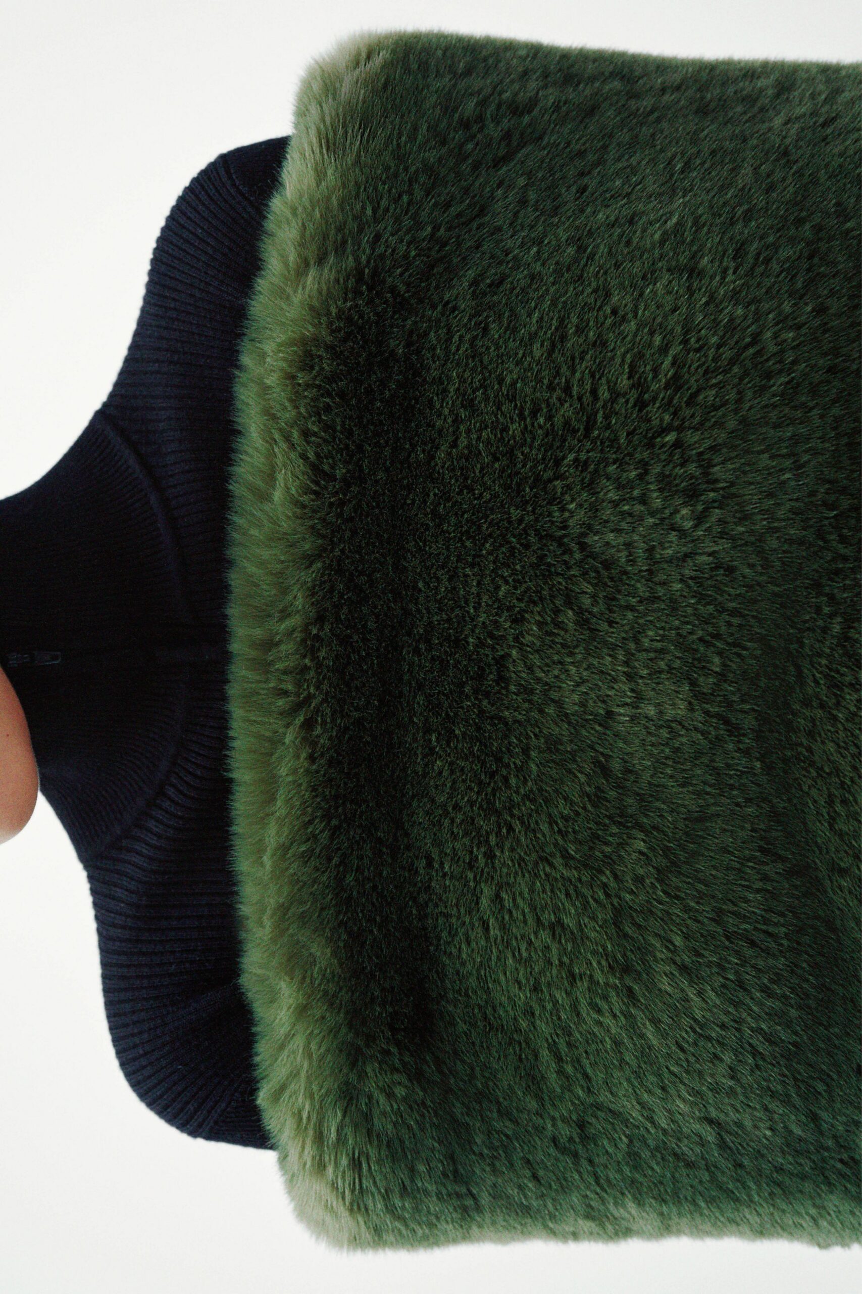 green faux-fur vest and black knit jacket
