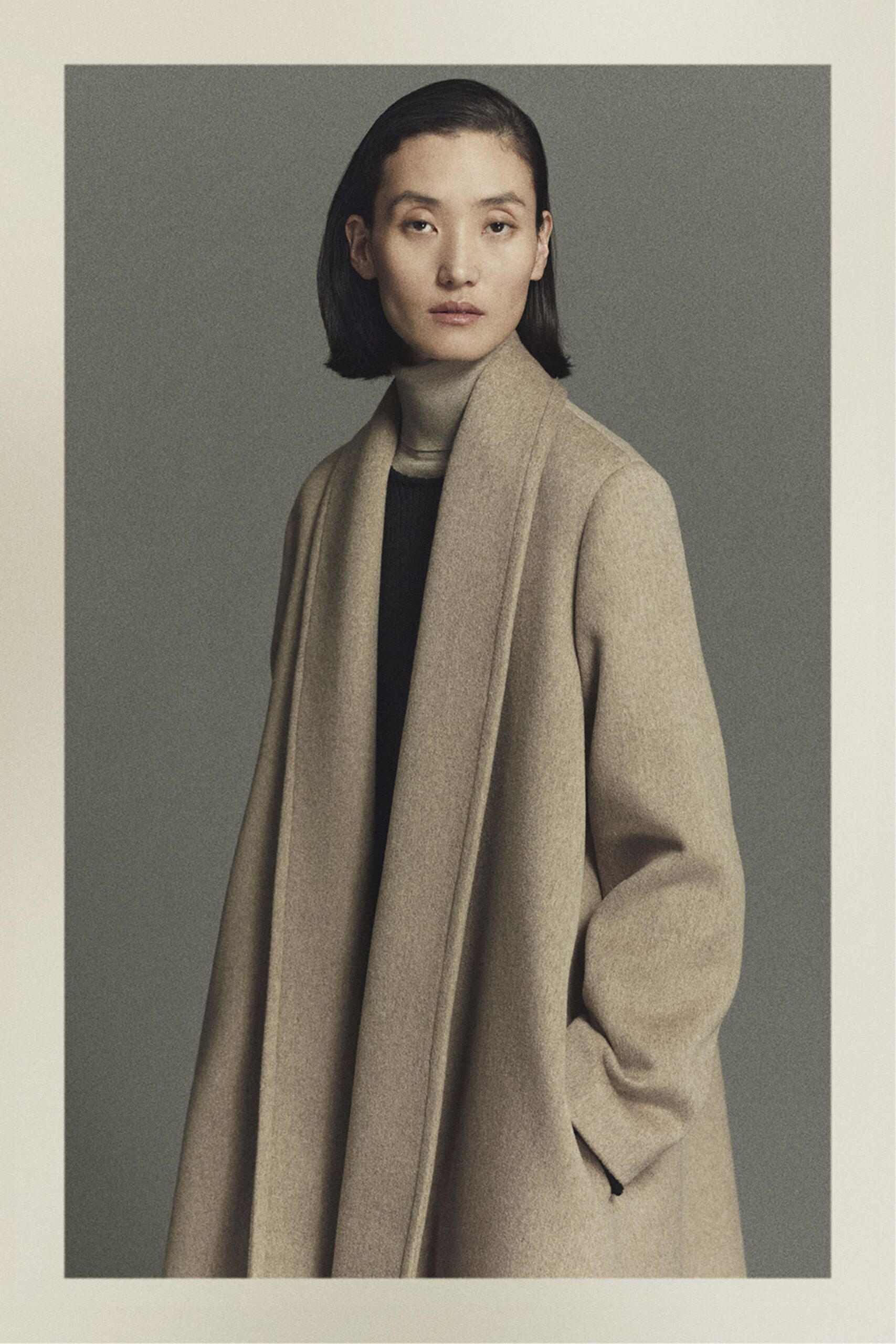 beige wool relaxed coat and black fitted top