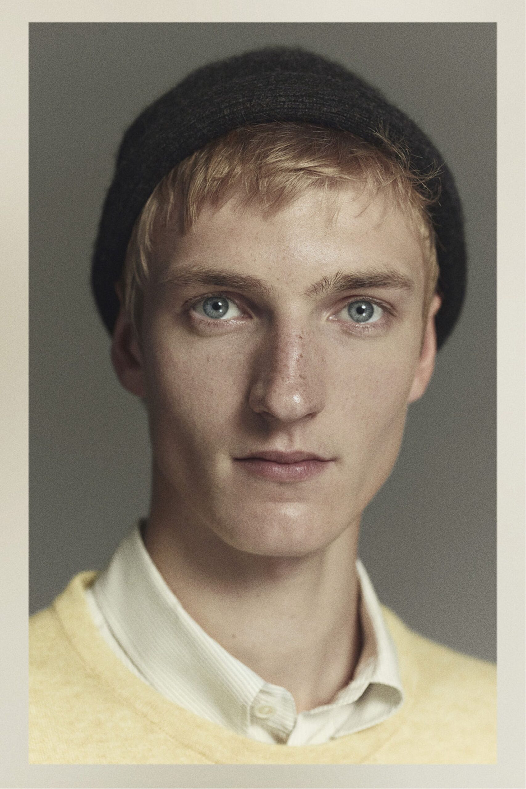 yellow sweater white shirt black hat