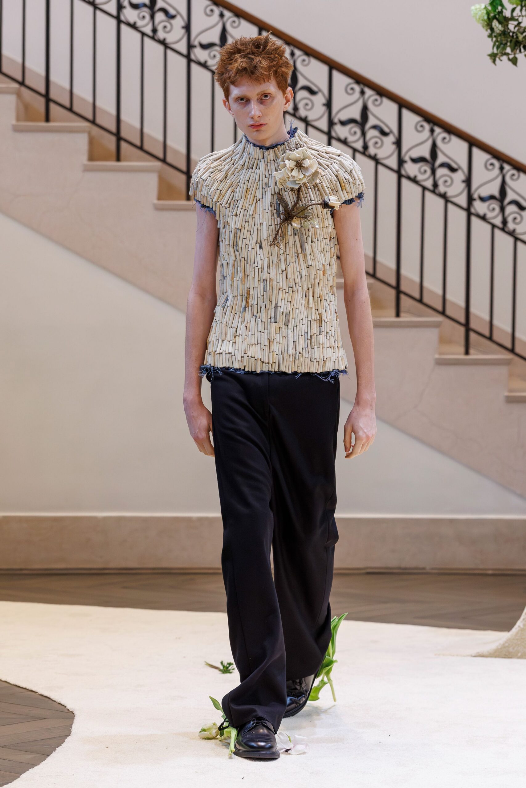 beige pleated sleeveless top with black tailored pants