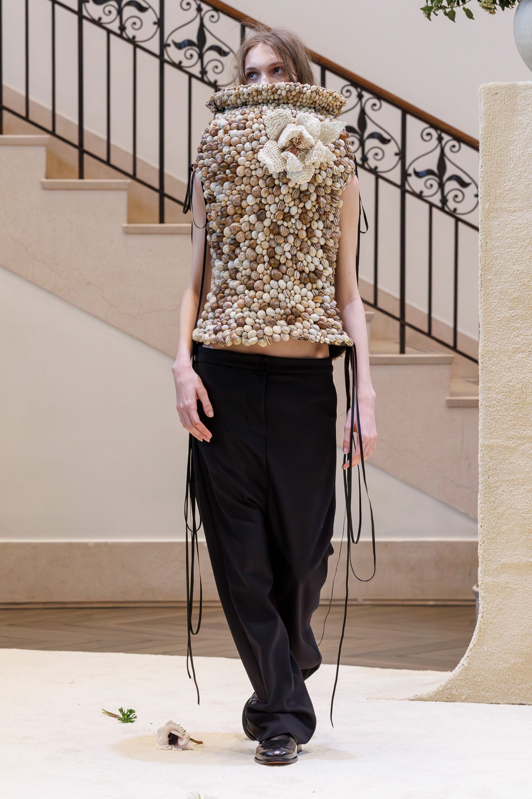 beige textured sleeveless top with black pants