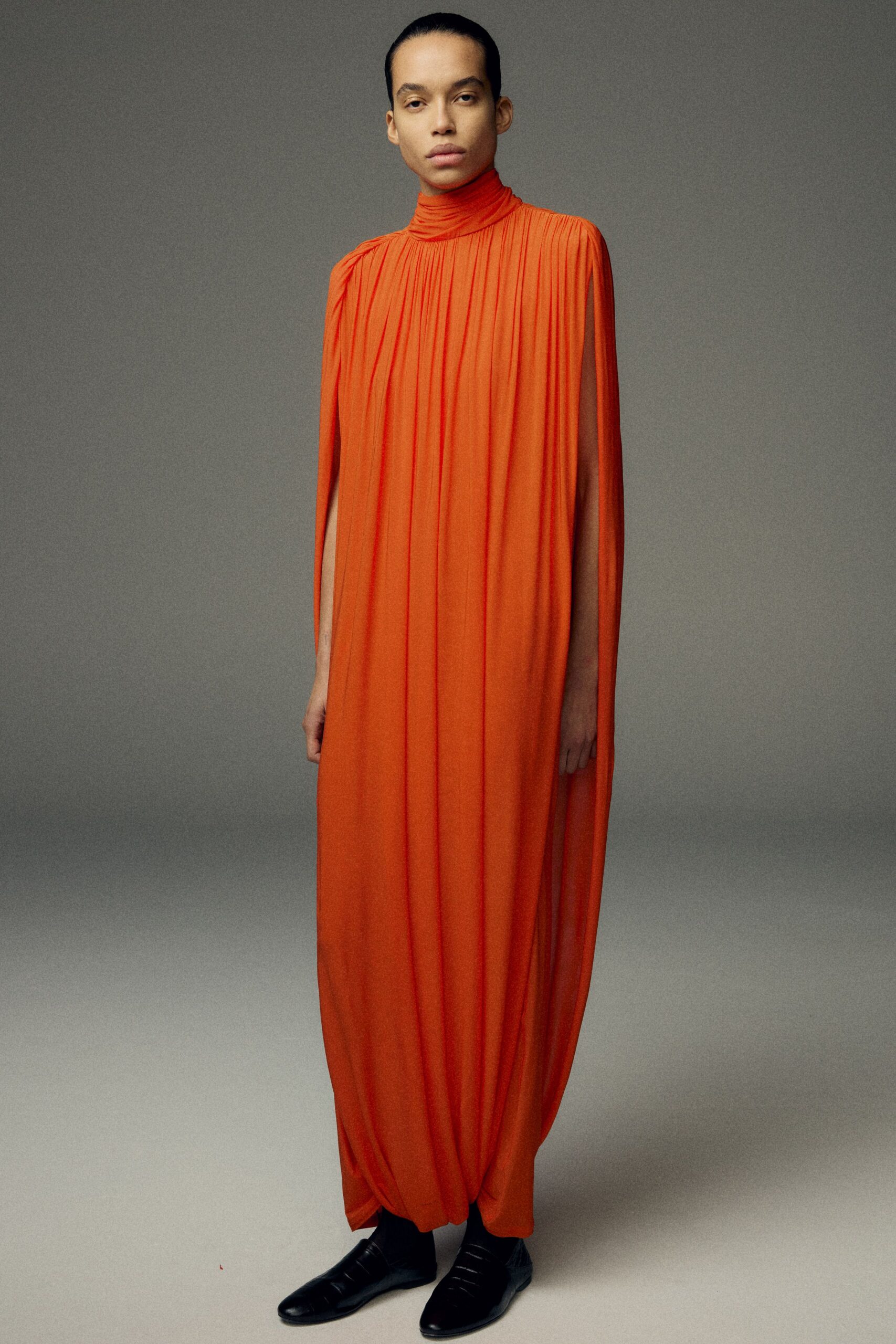 orange silk long-sleeve high-neck relaxed pleated flowing gown