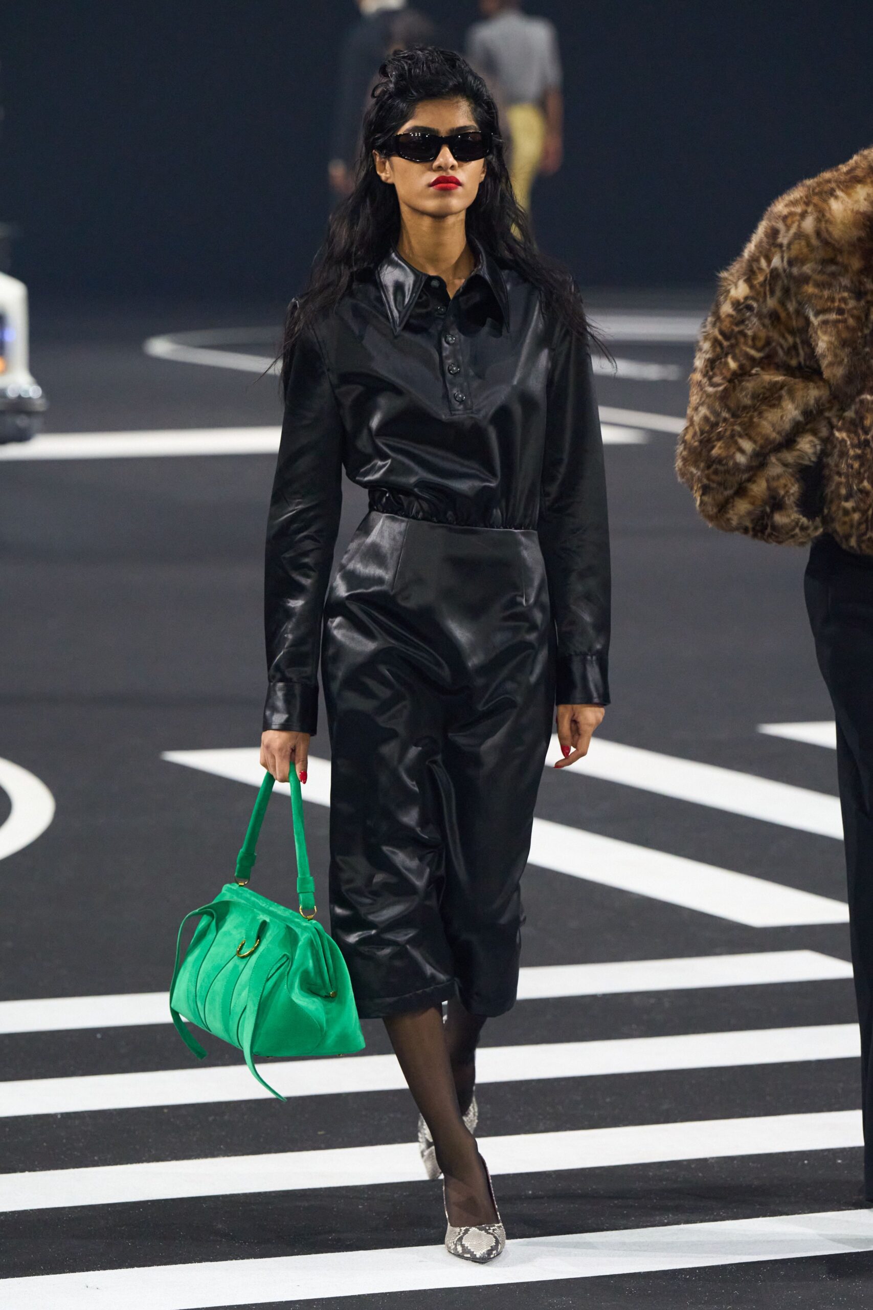 black leather fitted jumpsuit with green bag