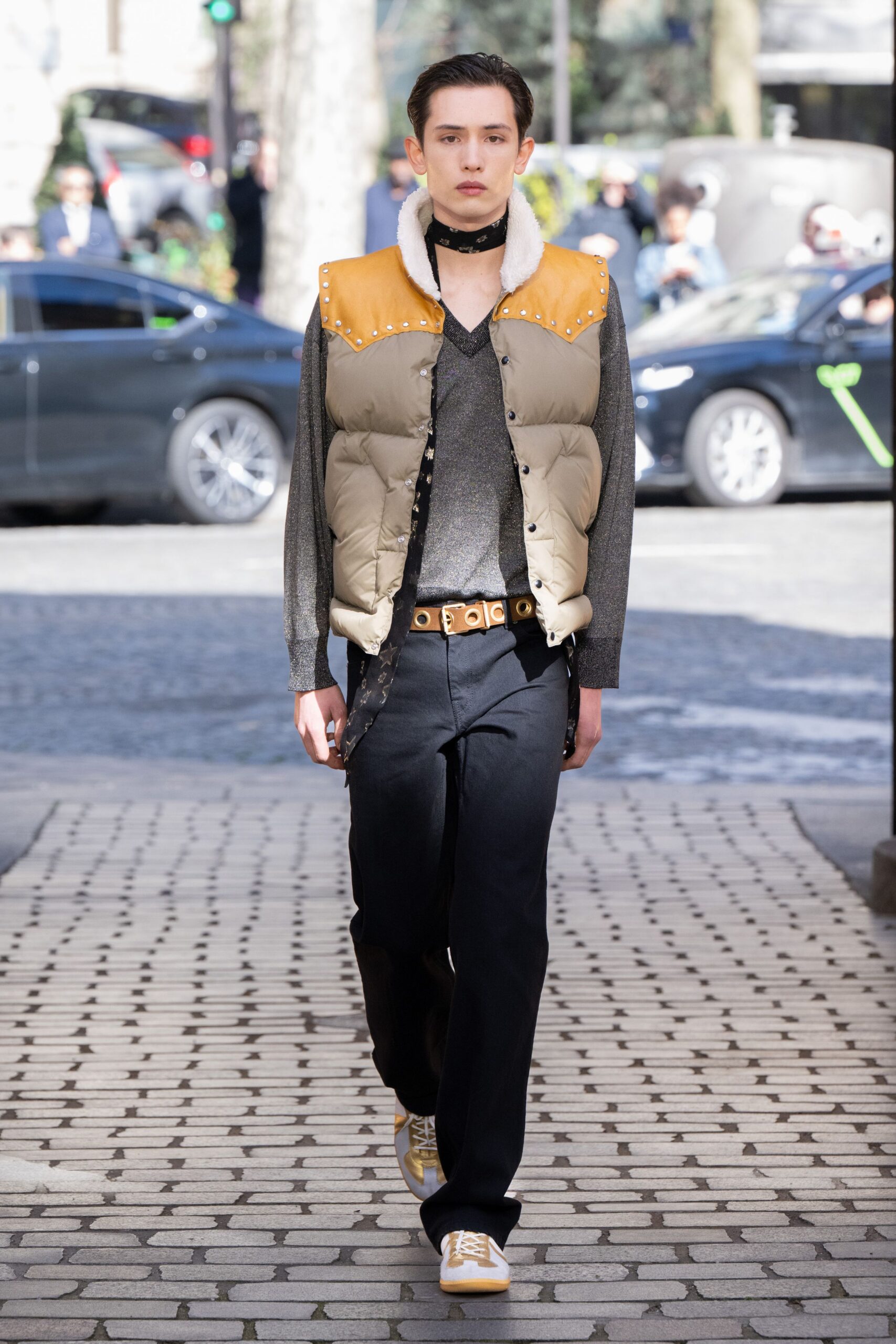 beige padded vest gray shirt black pants