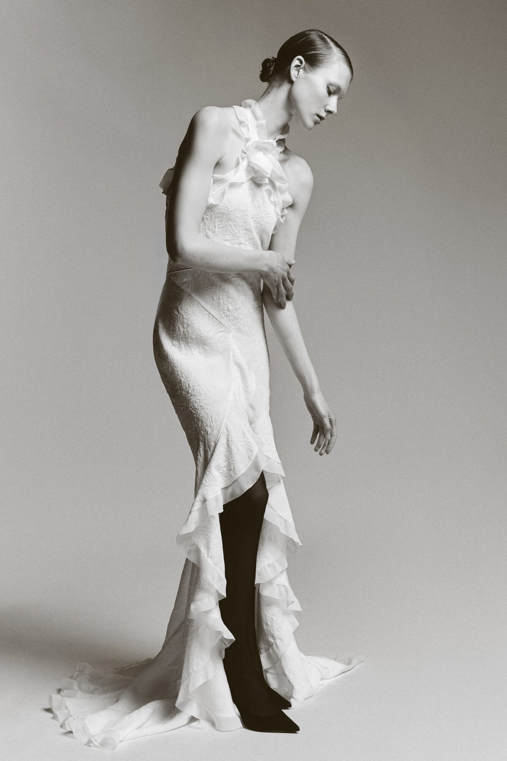 white silk sleeveless high-neck fitted ruffled tiered gown