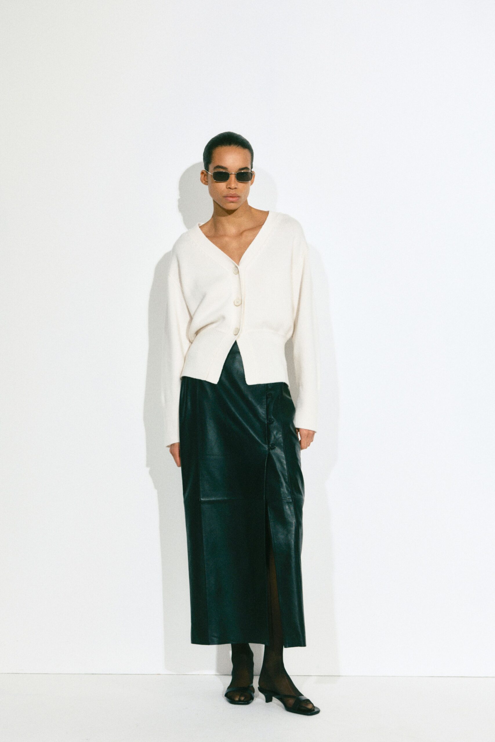 white cardigan black leather skirt