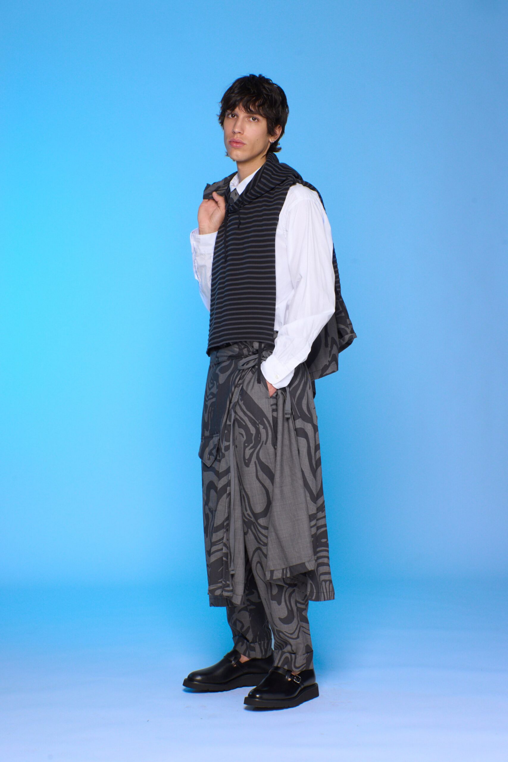 white shirt with black vest and gray pants