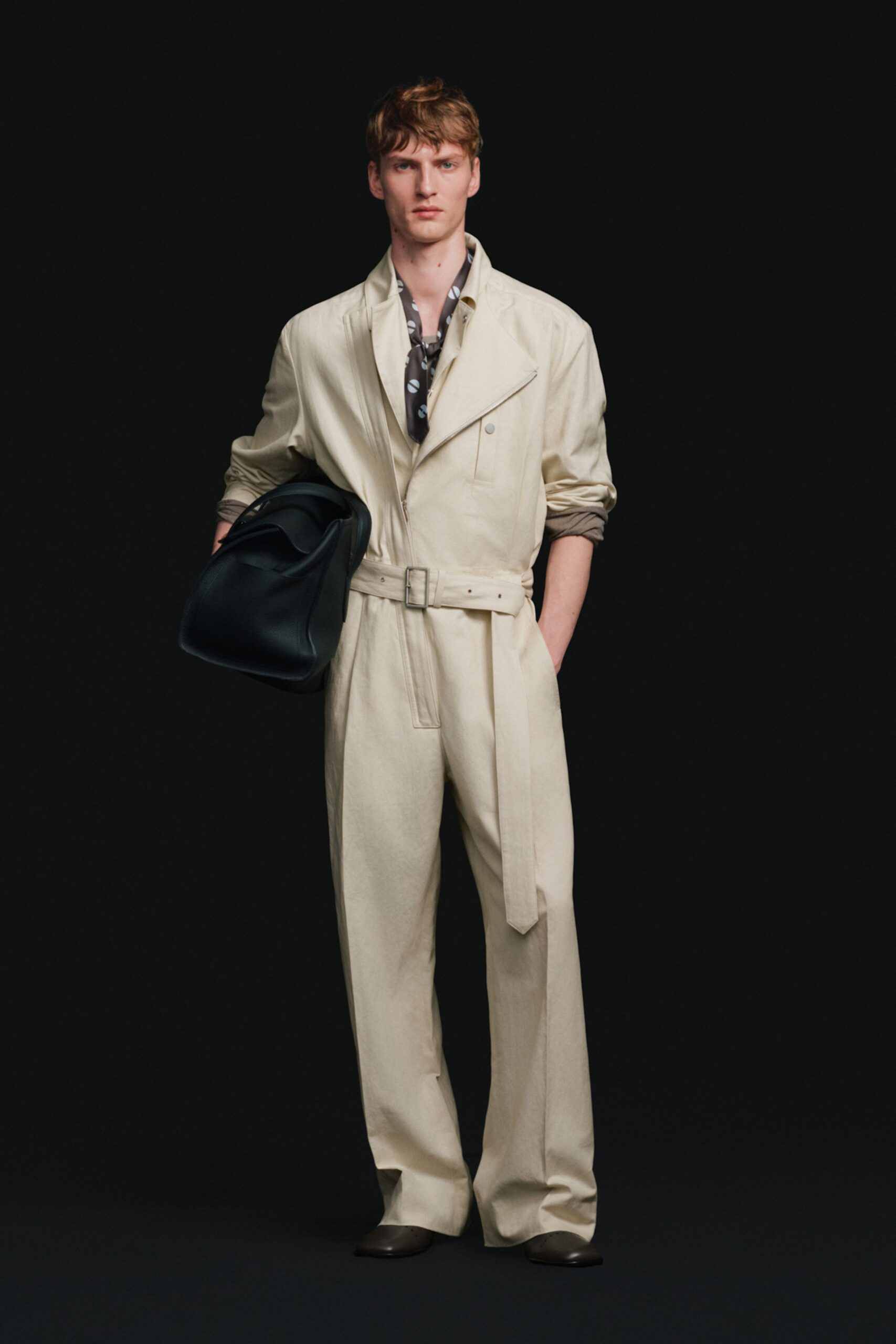 beige relaxed jumpsuit with black bag