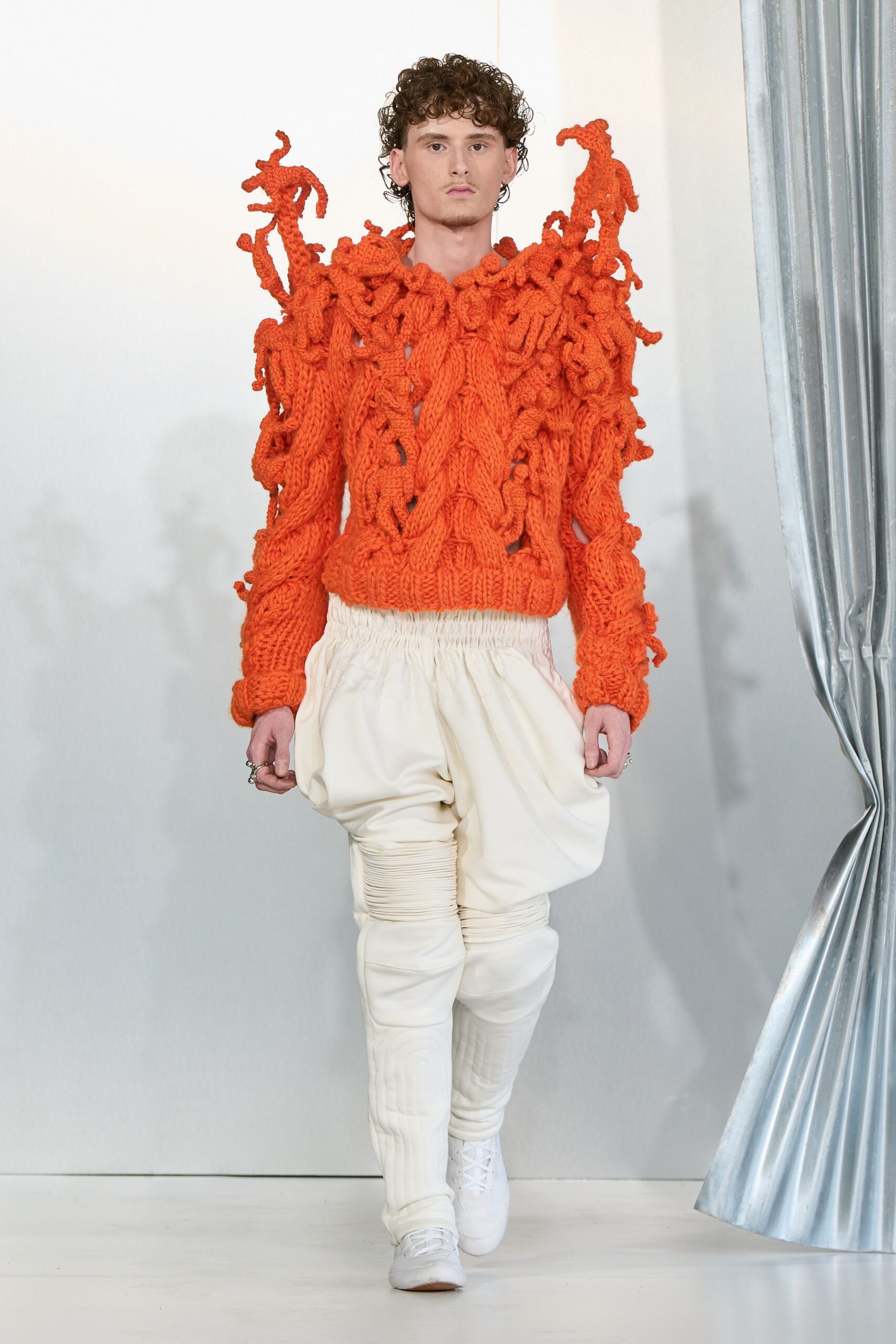 orange textured sweater with white pants