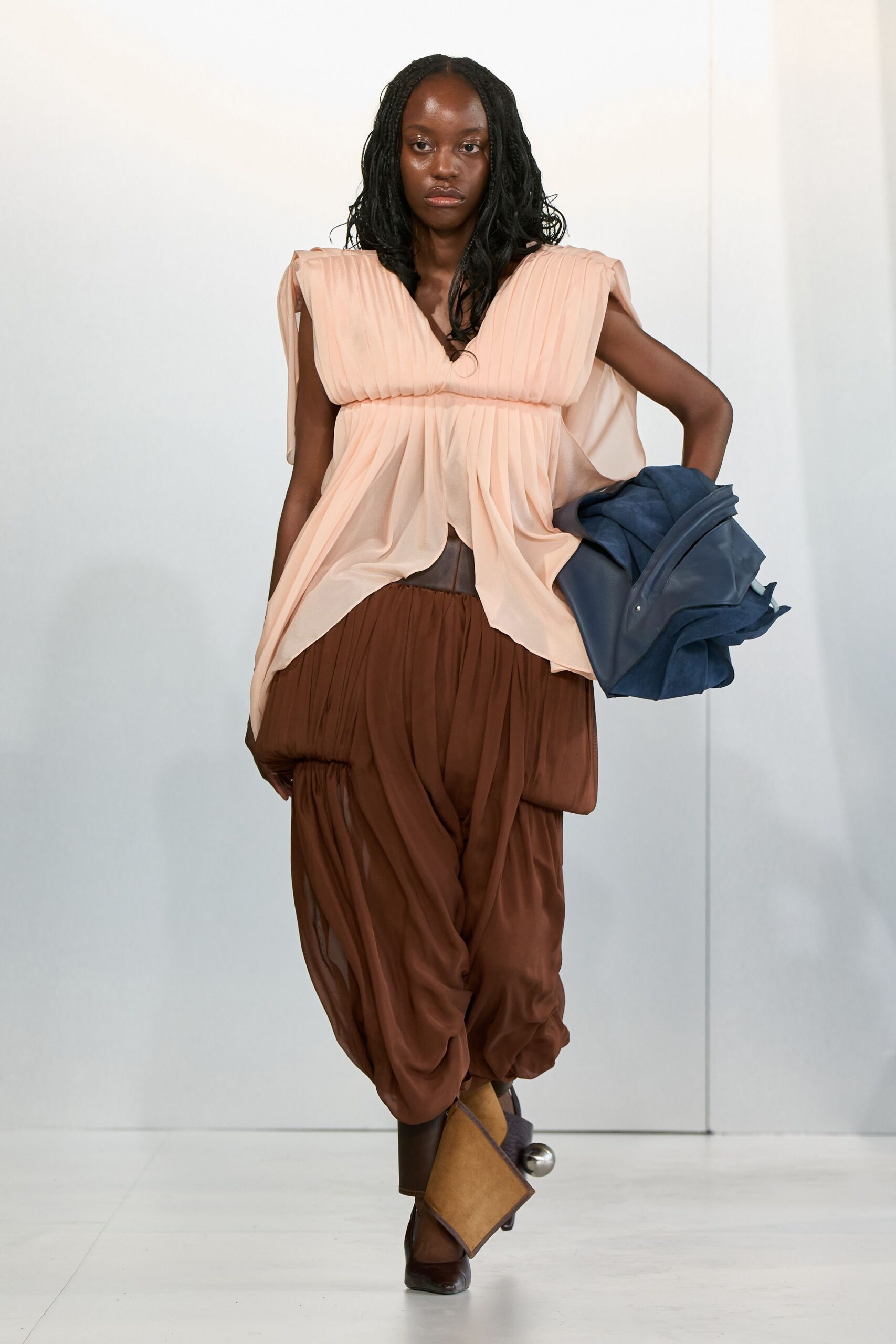 pink silk pleated top with brown pants