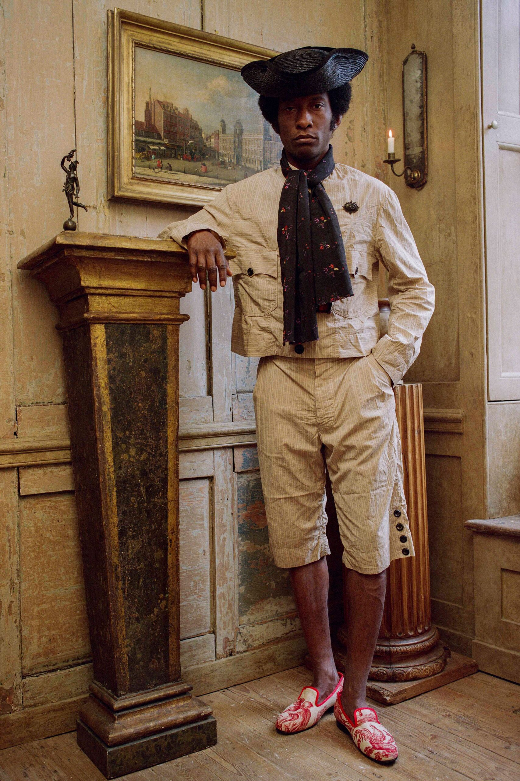 beige jacket and shorts with black hat
