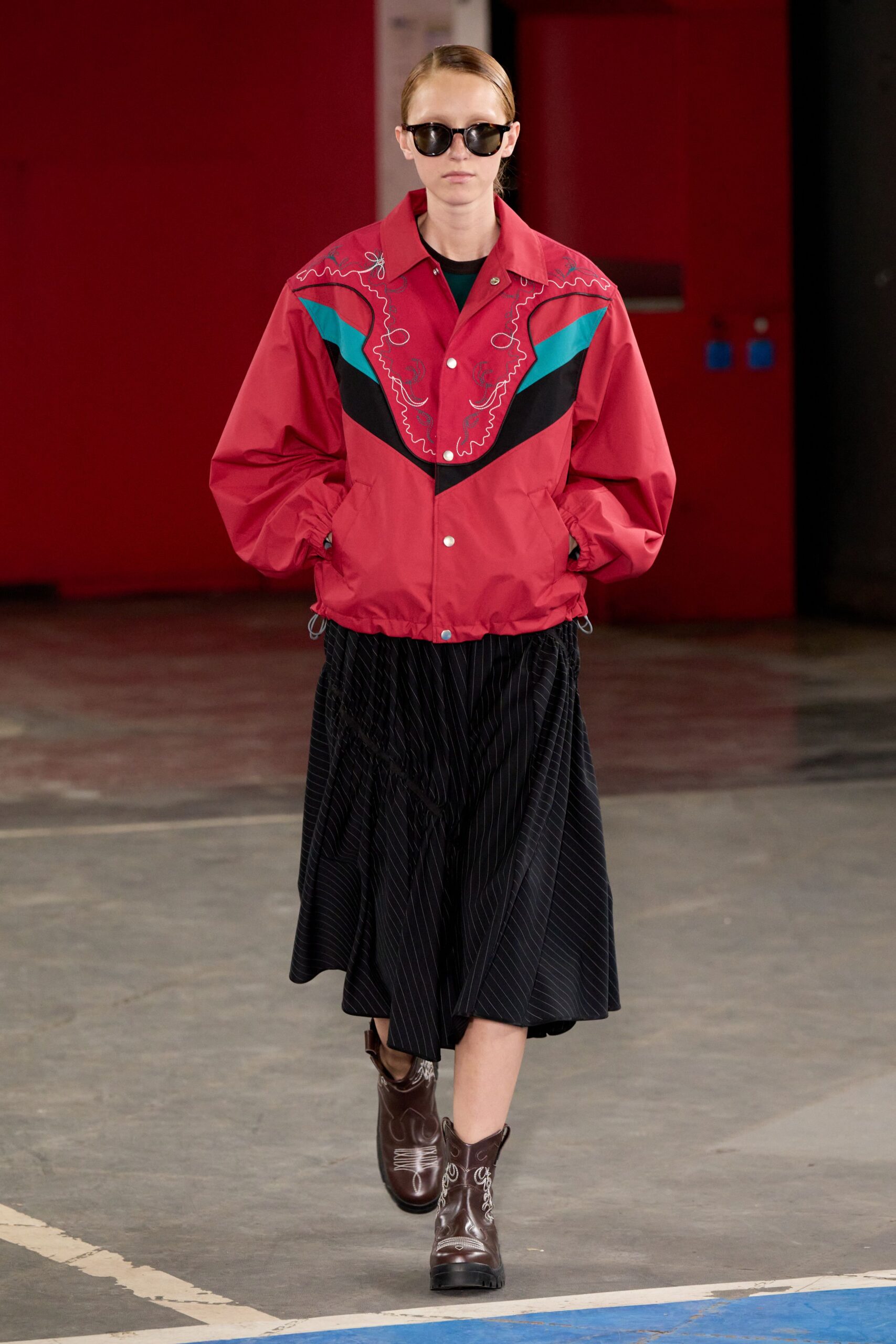 red embroidered jacket with black pleated skirt