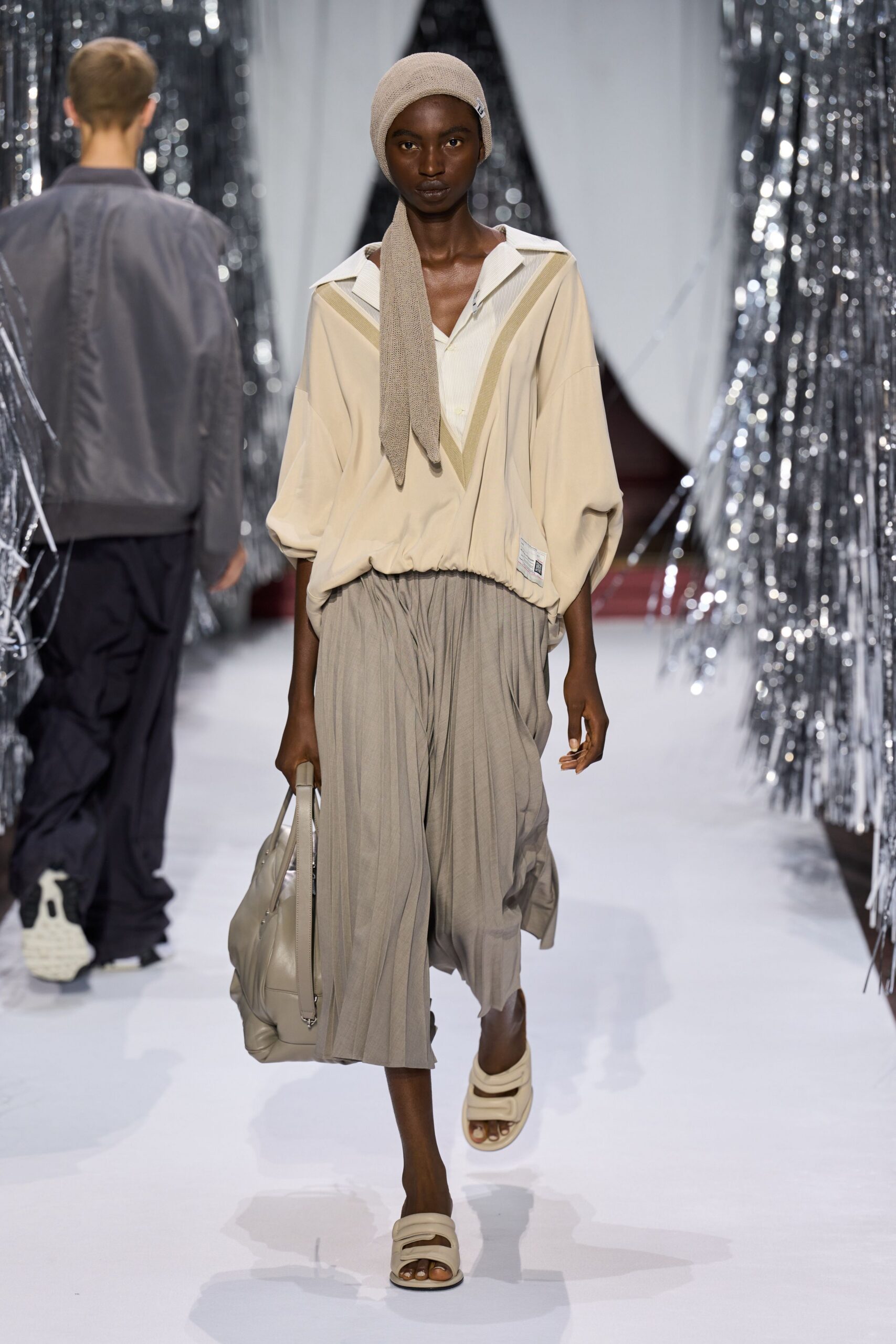 beige relaxed top with pleated gray skirt
