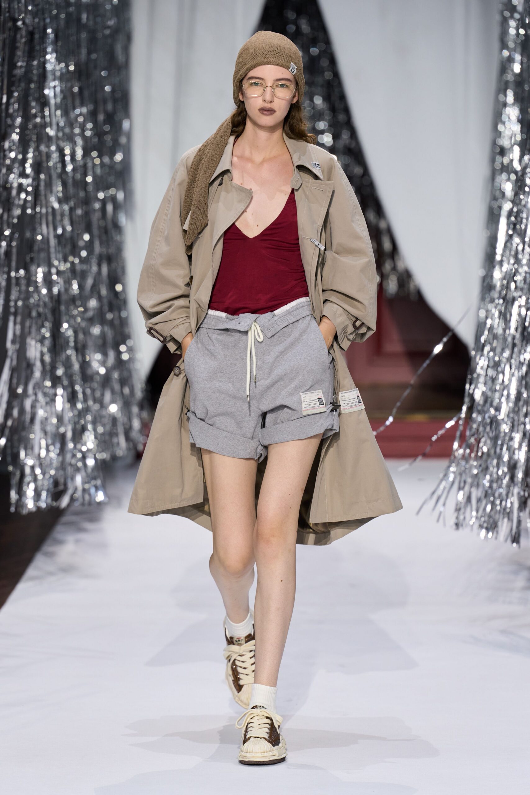 beige coat red tank-top gray shorts