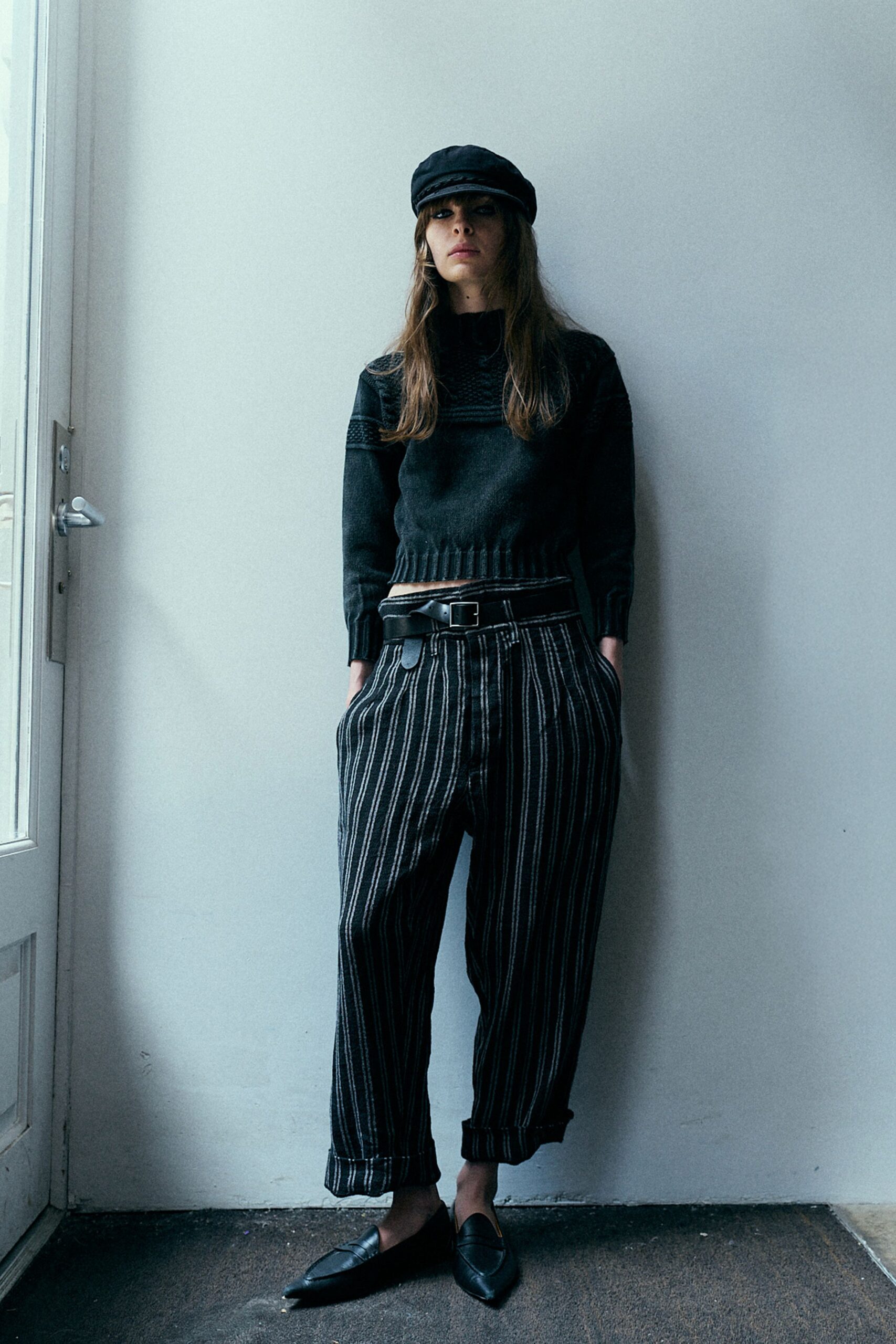 black sweater and striped pants