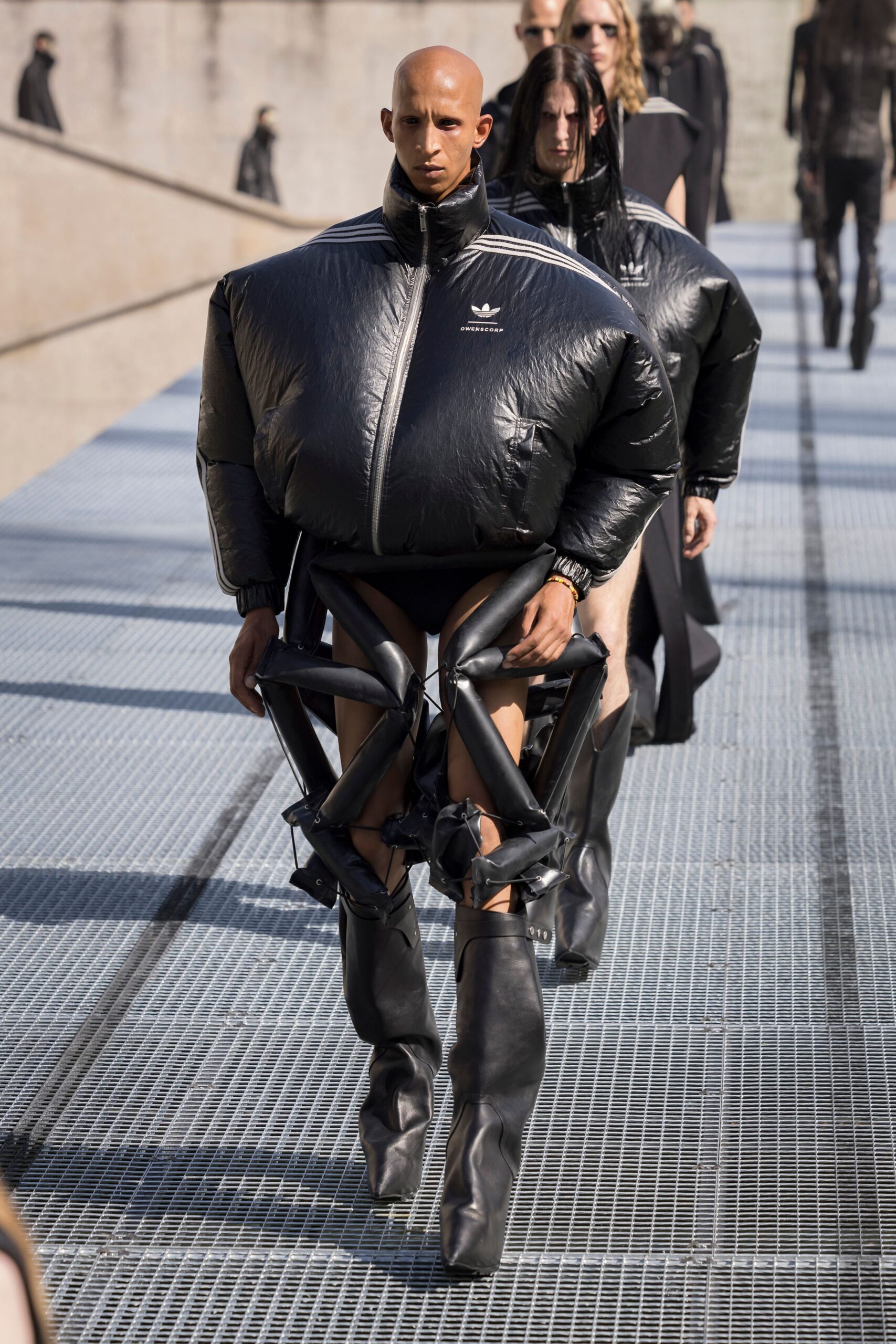oversized black vinyl jacket with fitted pants and boots