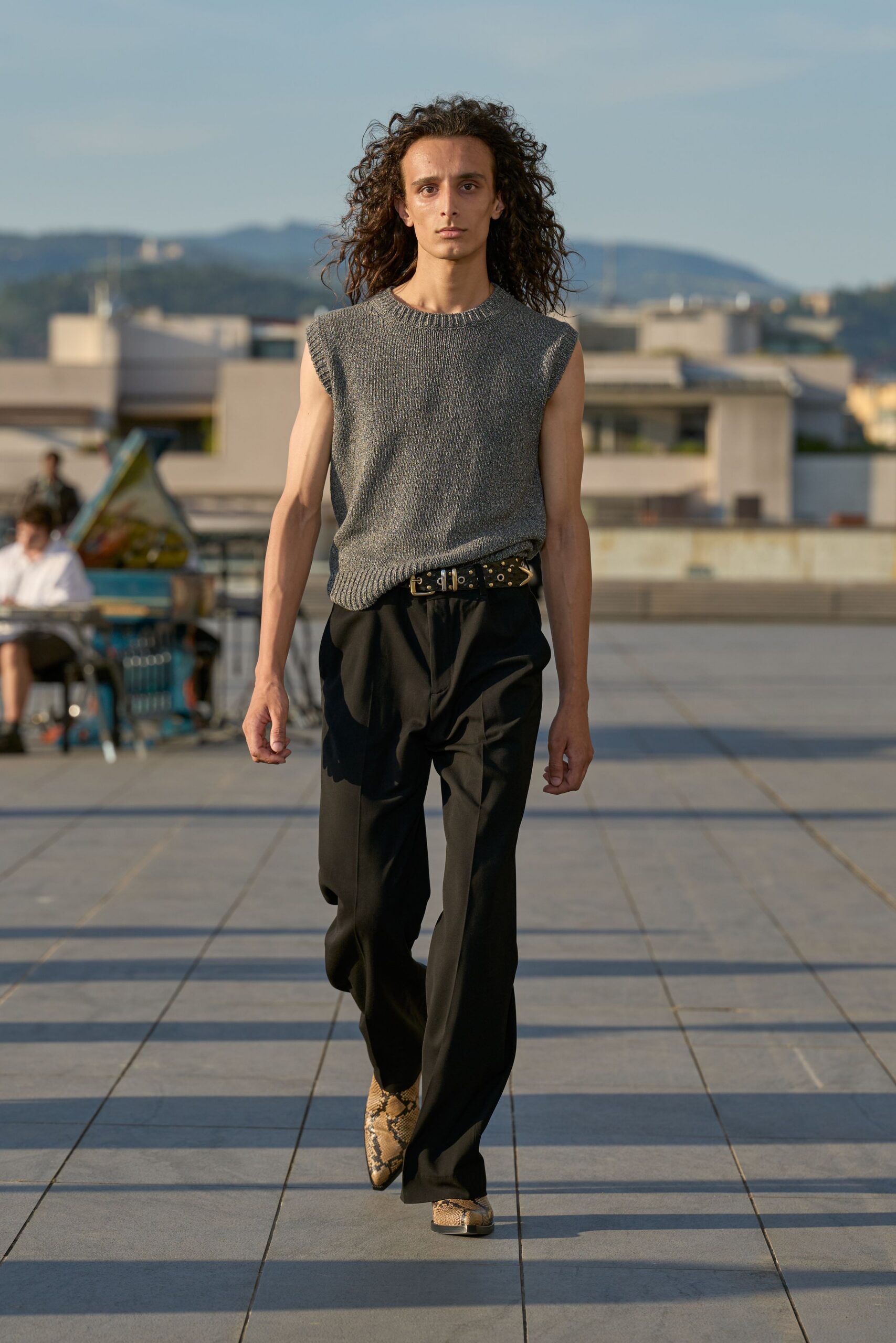 gray sleeveless sweater with black pants