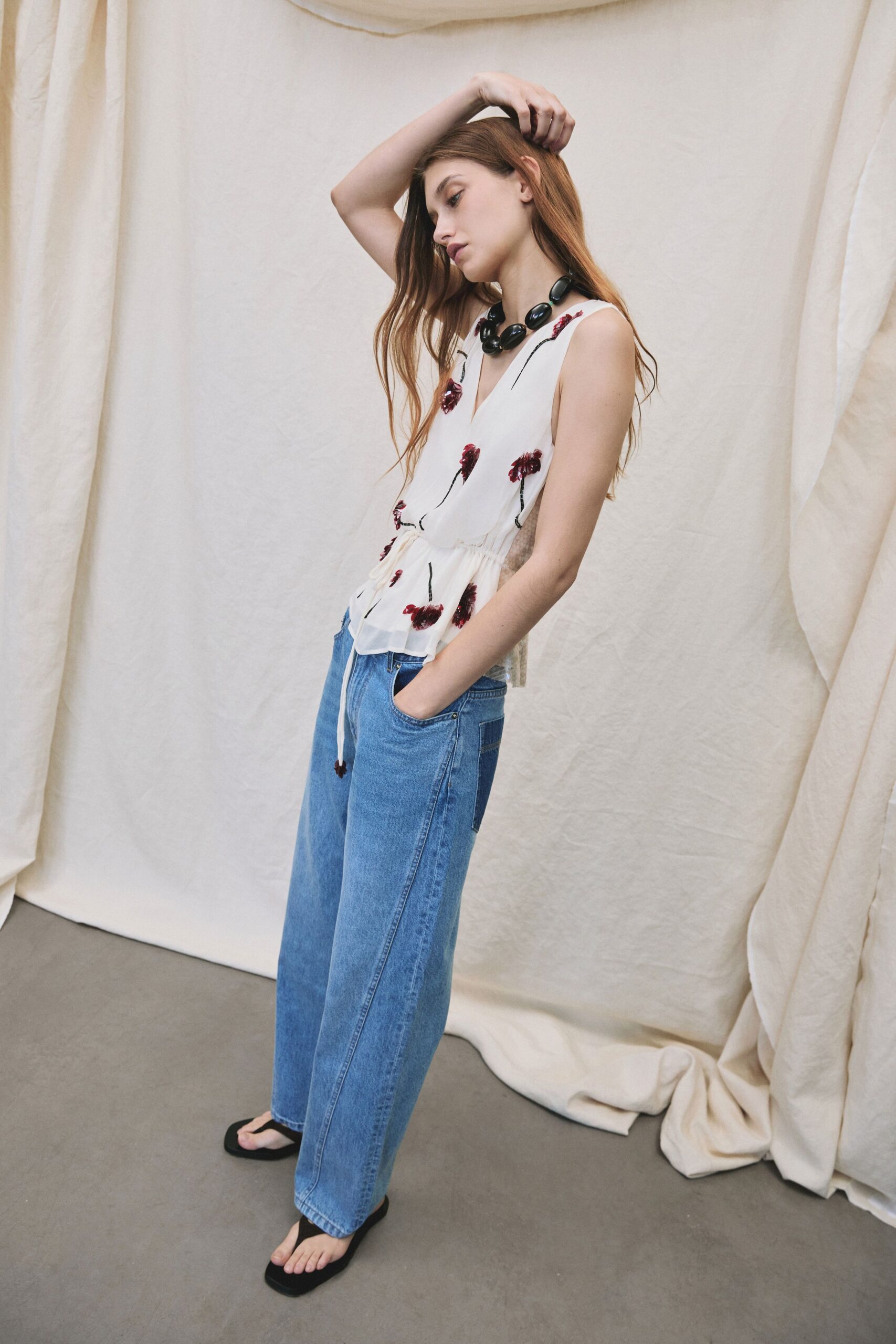 white ruffled top with blue wide-leg pants