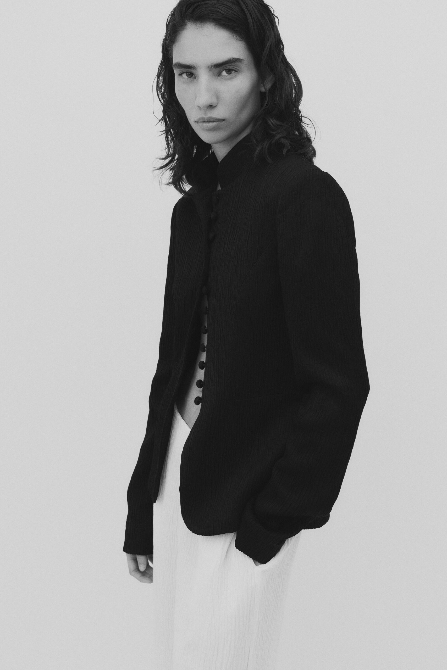 black structured jacket and white pleated dress