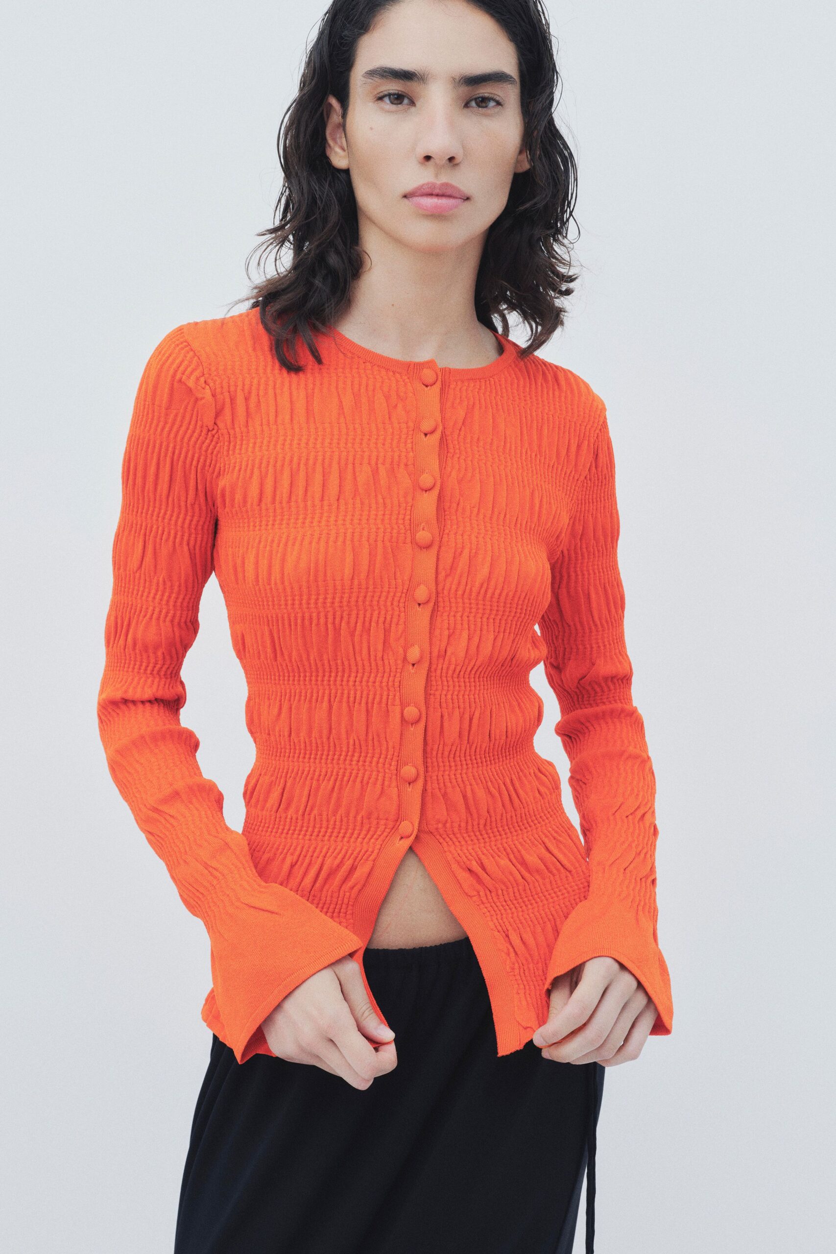 orange fitted top with black pants