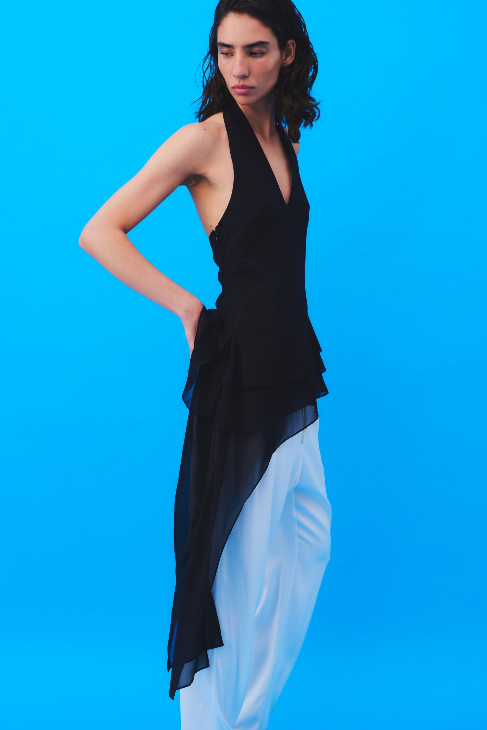 black silk sleeveless top with white pants