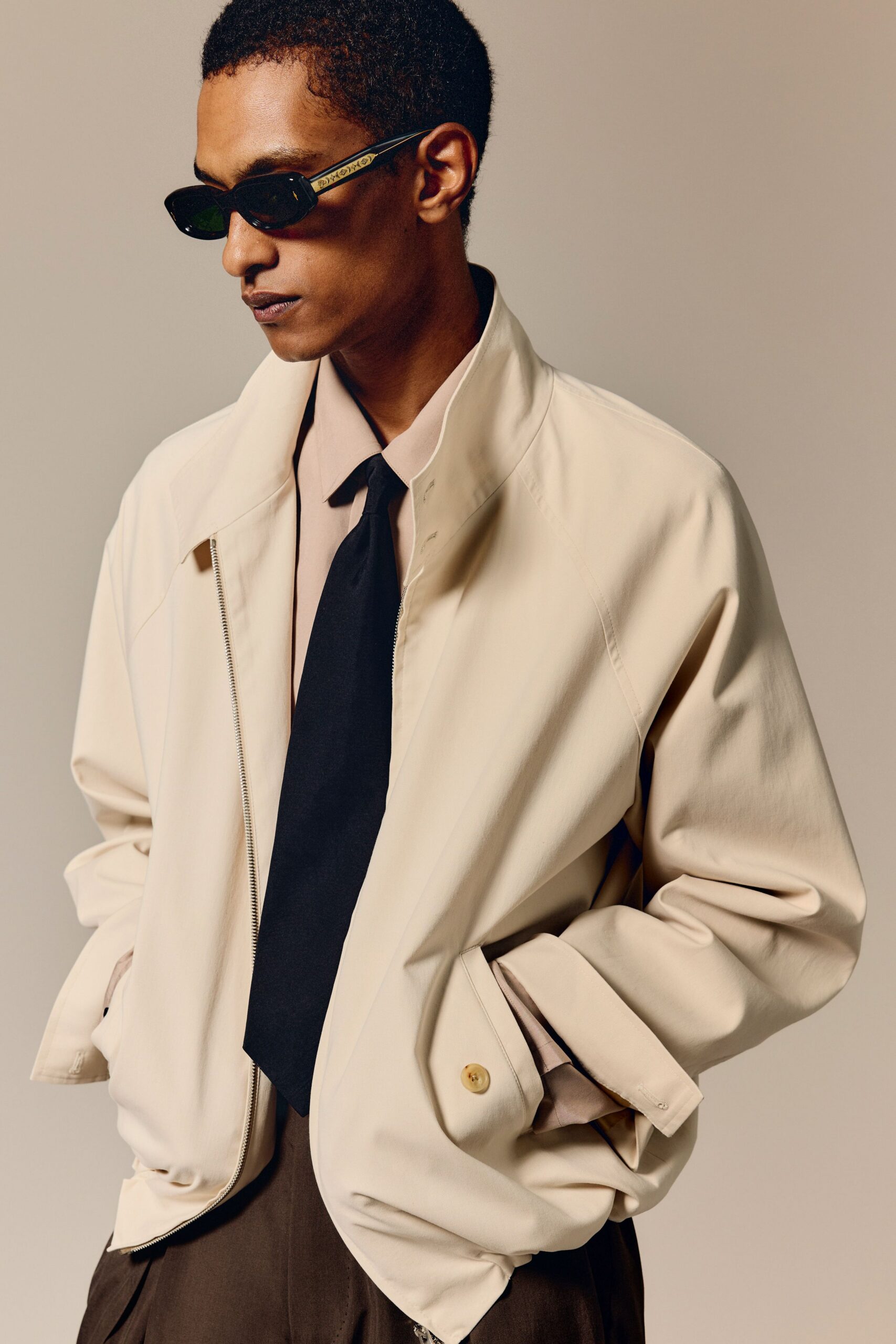 beige relaxed jacket with black tie