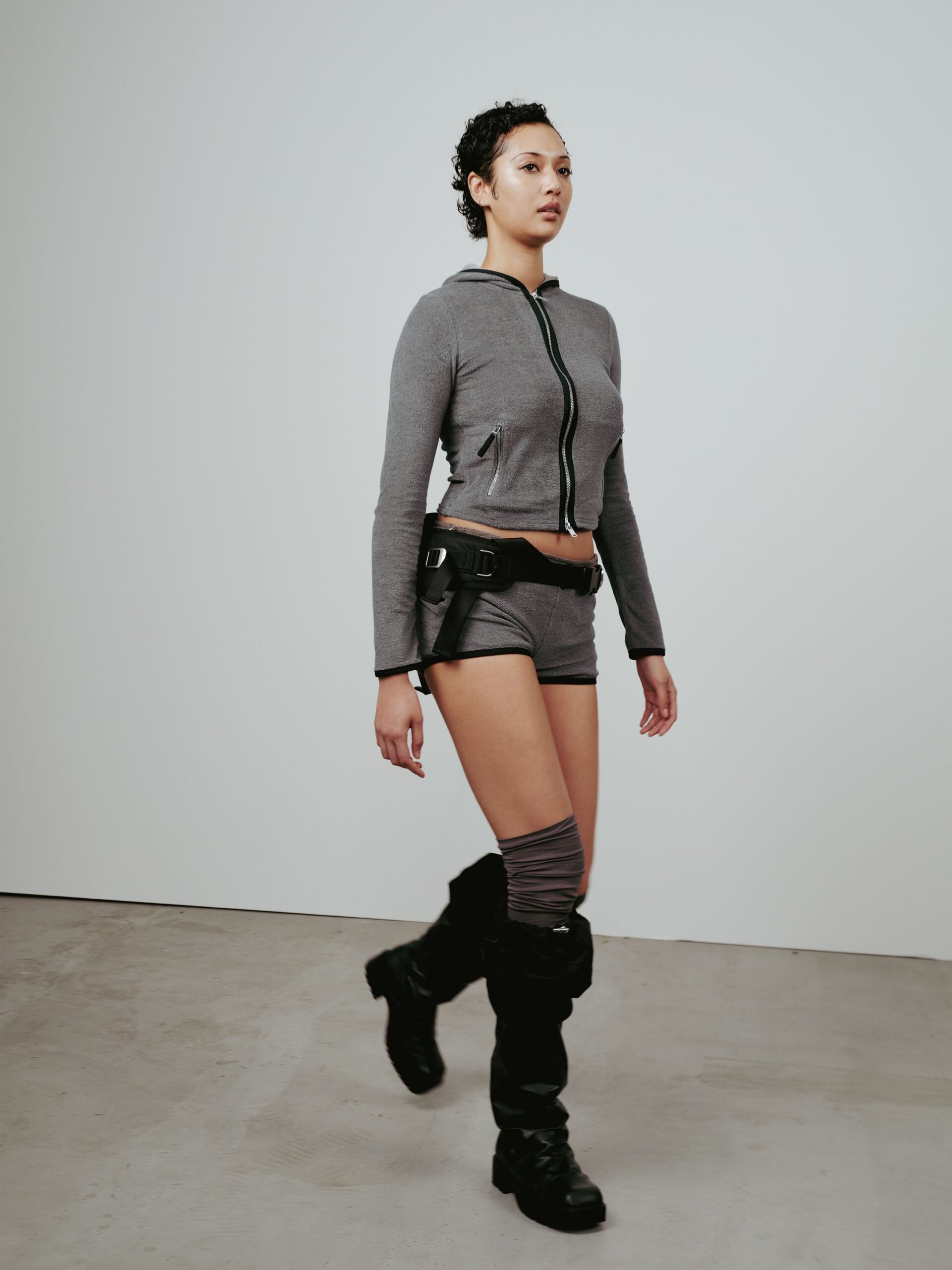 gray cropped hoodie with shorts and boots
