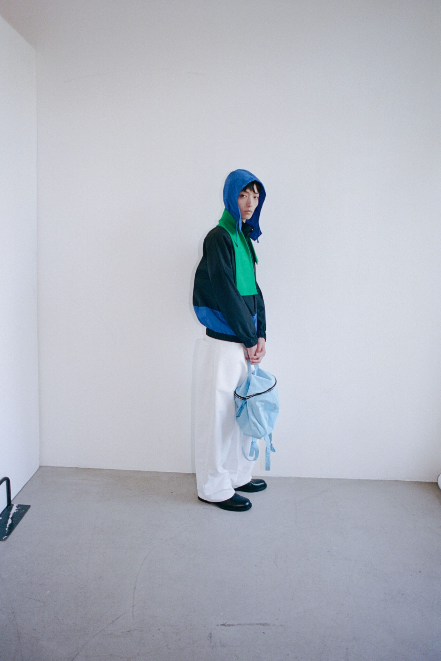 blue green hooded jacket with white pants