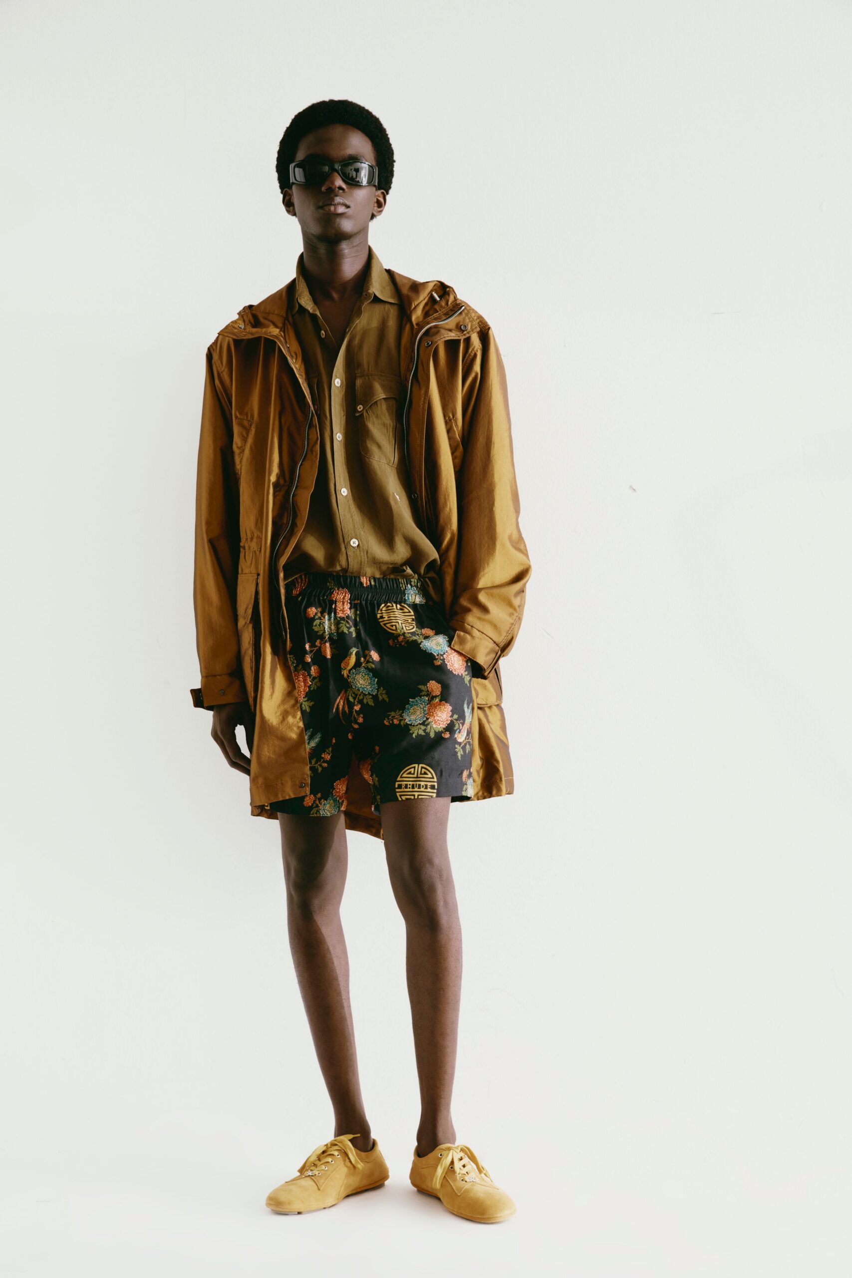 brown jacket olive shirt black shorts yellow shoes