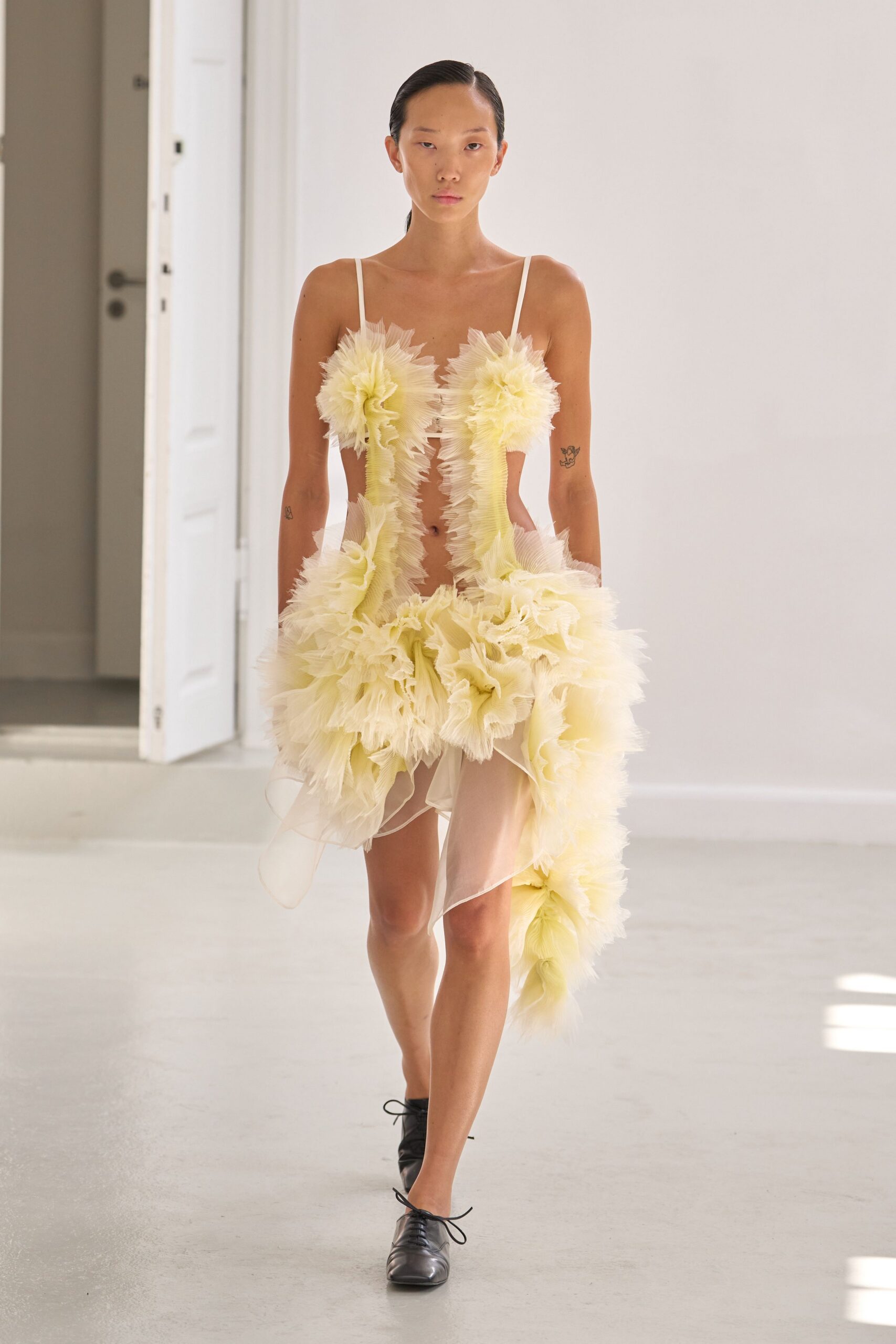 yellow ruffled mini dress with black shoes