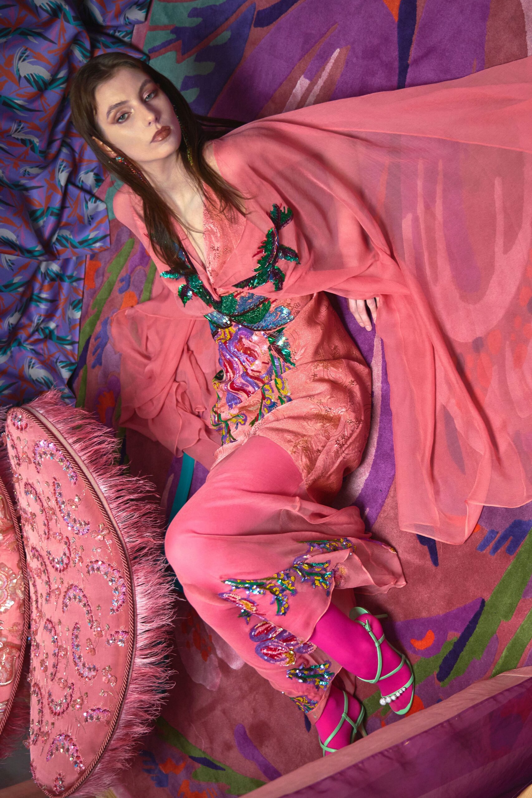 Blush chiffon tunic with cape sleeves and sequin fronds climbing the neckline, over blush jacquard trousers stitched with beaded florals at the cuff. Hot-pink tights, mint lace-up sandals. Sprawled in a hotel suite after the wedding band packs up.