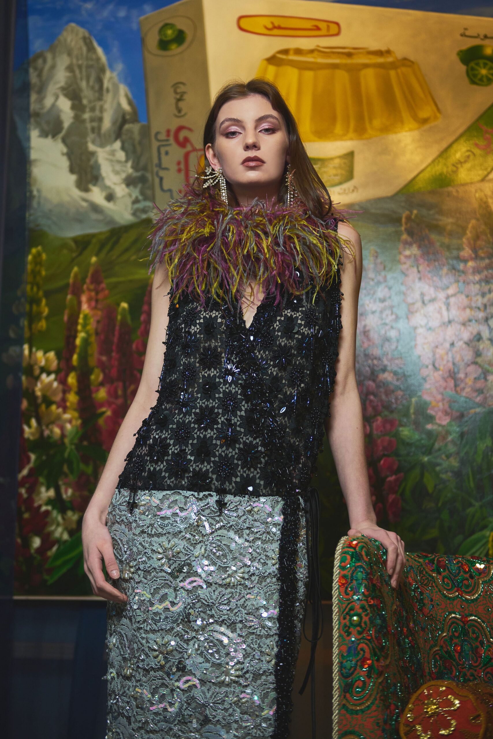 Black floral lace tunic drenched in jet beading, topped with a shaggy marabou collar in plum and moss. Pale mint lace column skirt crusted with sequins and pearls. Crystal fringe earrings. Under a restaurant mural no one has updated in decades.