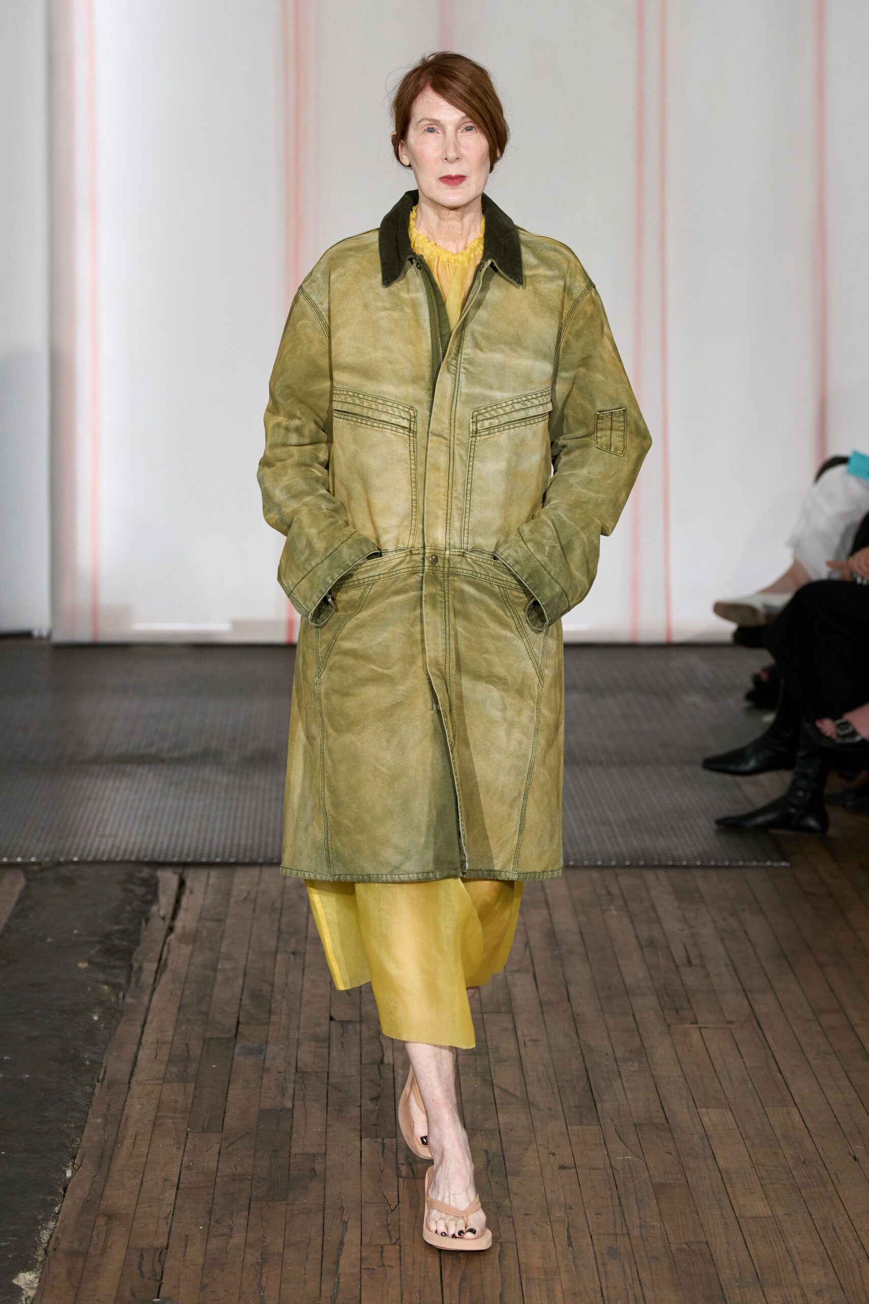 Washed olive leather coat with a black corduroy collar and triple chest topstitching. Buttery yellow dress, gathered neckline peeking out beneath the coat. Nude thong sandals with square toes. For walking across a dewy lawn before anyone brings out the folding chairs.
