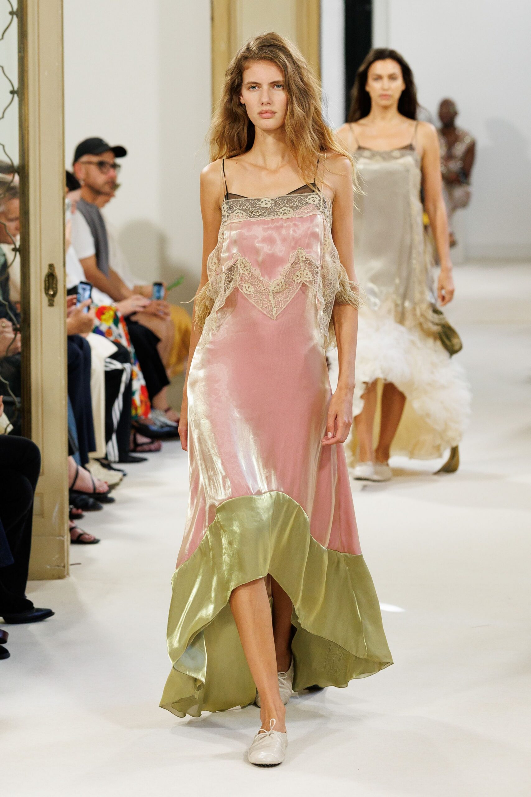 Blush satin slip dress with black mesh neckline and ecru lace draped loose. White lace-up flats, softly creased at the vamp. Sunday hotel corridor, carrying yesterday's bouquet back downstairs.