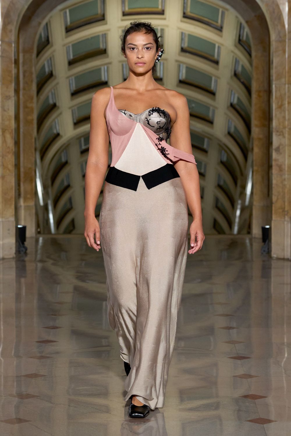 Blush and ivory slip dress spliced with a corset cup and black beading. Black square-toe flats peeking from the champagne satin hem. Crystal ear cuff climbing one ear like a clipped sprig. Crossing a museum atrium after the string quartet has packed up.