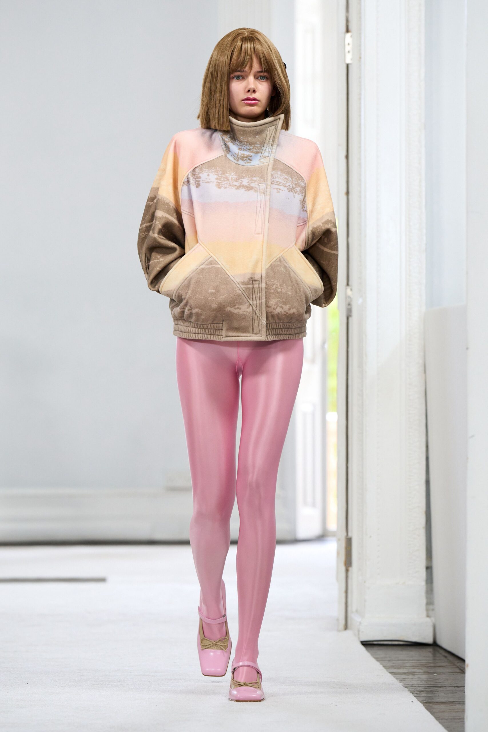 Airbrushed fleece pullover in blush and taupe, with a tall wrapped funnel neck. Glossy bubblegum tights catching light like poured latex. Square-toe pink Mary Janes with a tiny tan bow. Walking to the corner shop after snowmelt, still wearing yesterday's sleepover clothes.