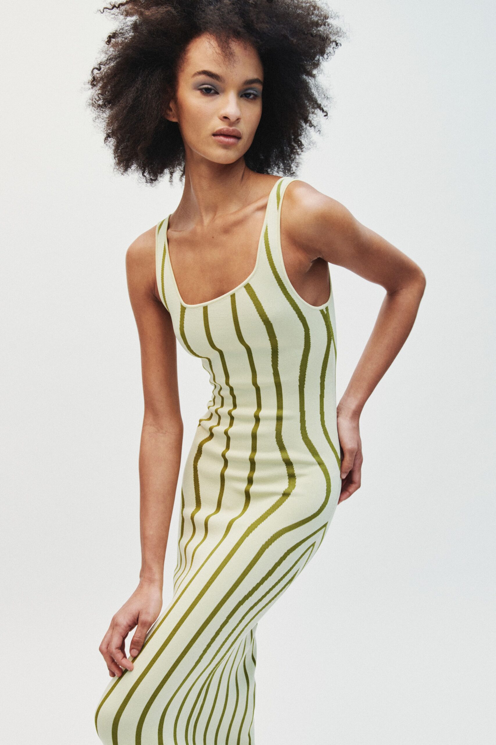 Pale pistachio knit tank dress with olive warped stripes pulling around the body. Heat rising off pavement after lunch, carrying nothing but keys.