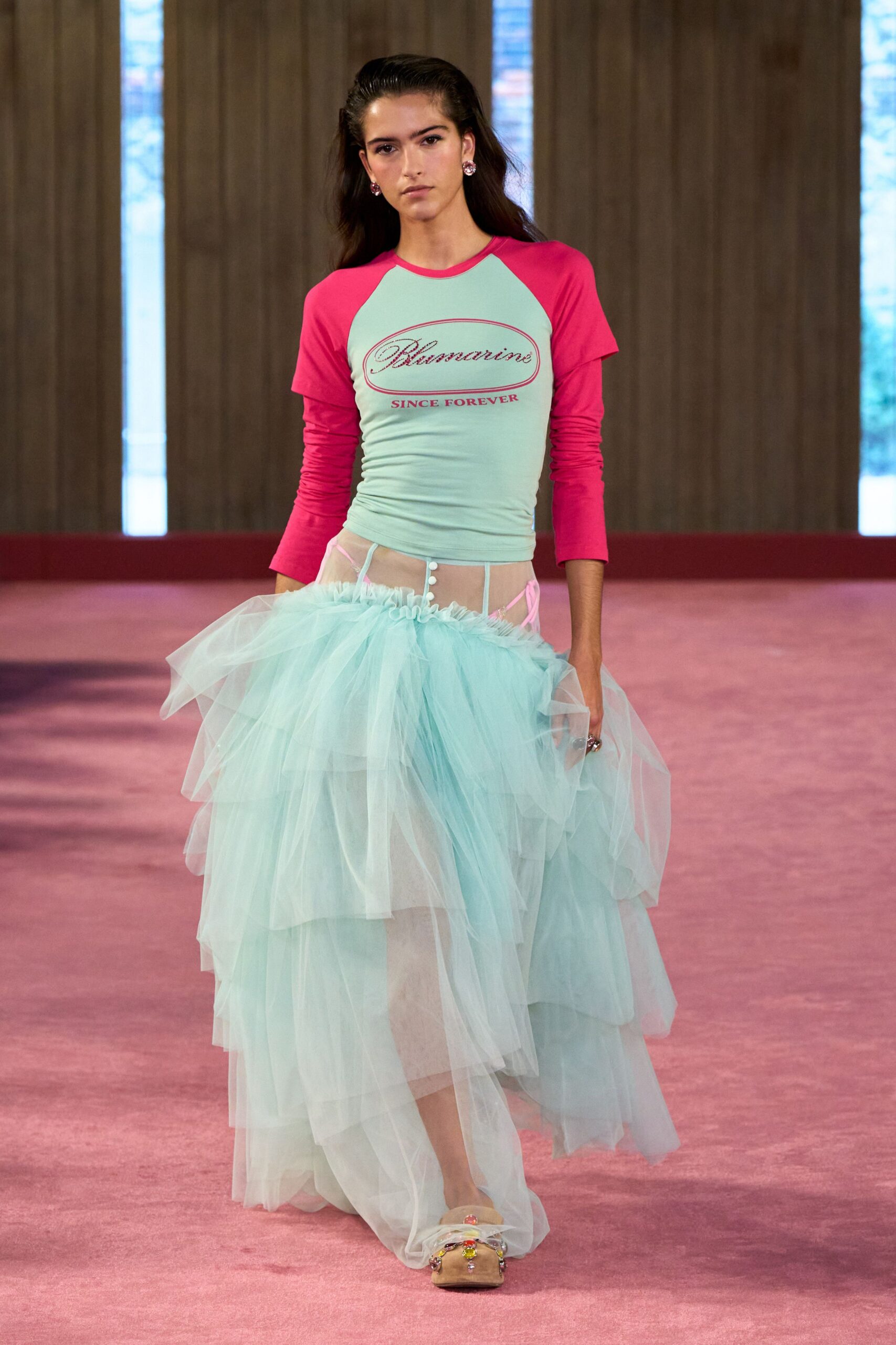 Mint fitted tee with hot-pink raglan sleeves and rhinestone script. Powder-blue tulle skirt, sheer yoke fastened with tiny white buttons. Nude slide sandals with clustered candy-bright jewels at the strap. For drifting downstairs at a faded seaside hotel after midnight cake.
