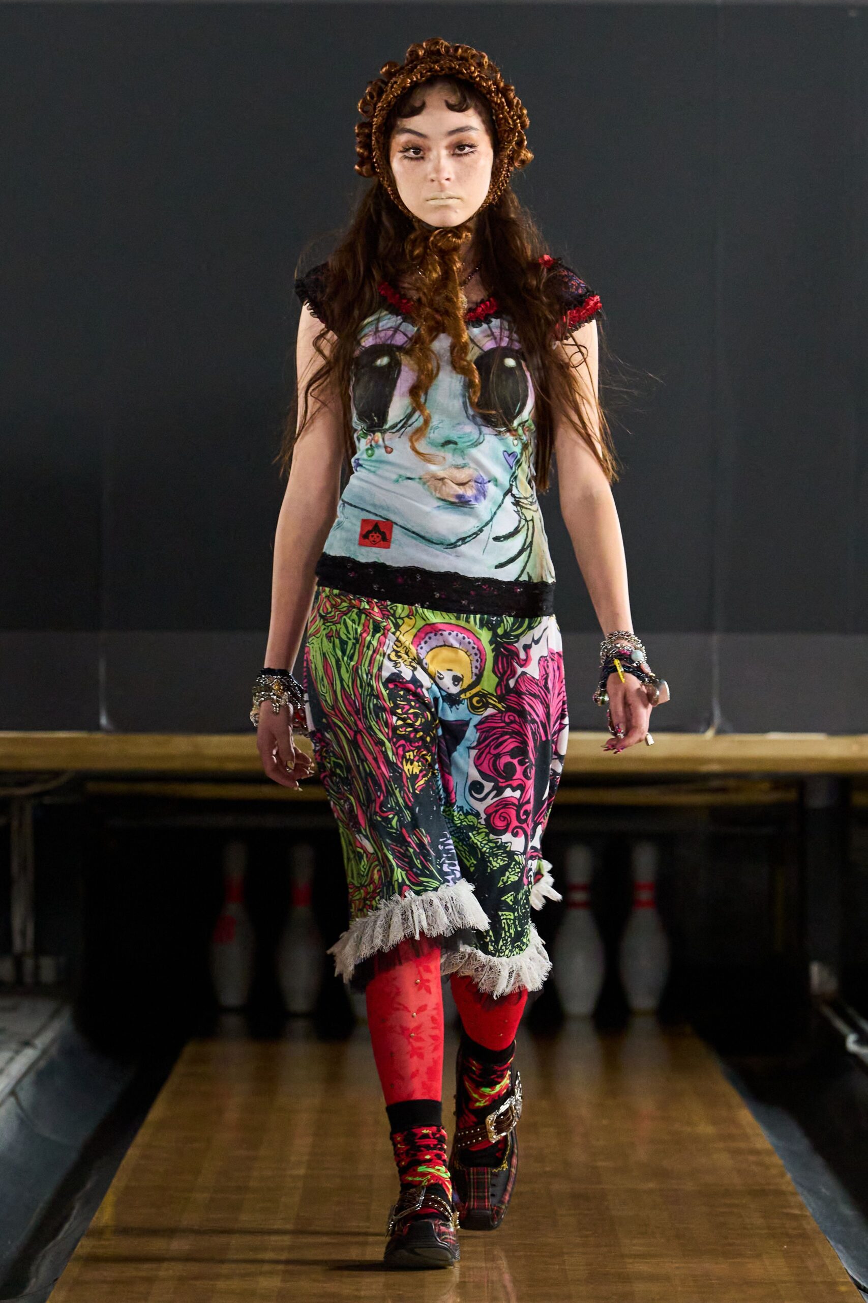 Brown crocheted bonnet with a long curled tie under the chin. Printed slip dress with a cartoon face bodice and black lace seams. Red floral stockings with tiny pearl-like studs. Mismatched patterned socks. Plaid platform shoes with buckled straps. After the church jumble sale, still wearing glitter from last night's fair.