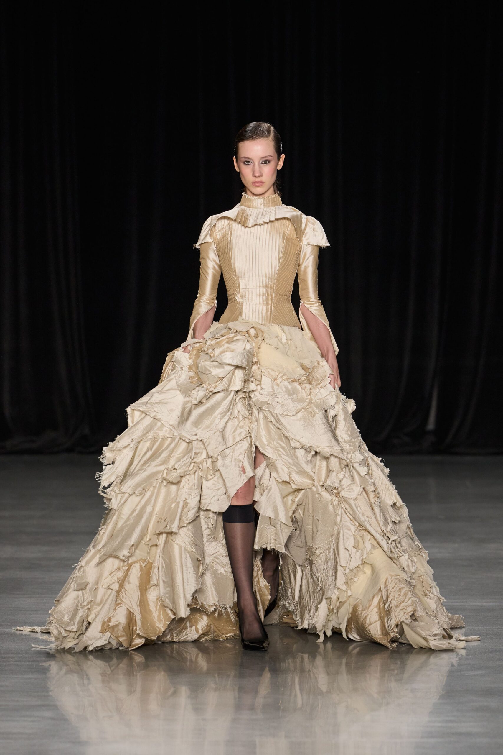 Champagne taffeta gown with a pleated bib, ruched collar, and frayed pannier skirt. Black sheer stockings with a dense band stopping below the knee. Black patent pumps peeking from the torn hem. Whatever survives the carriage ride after a wedding gone badly.