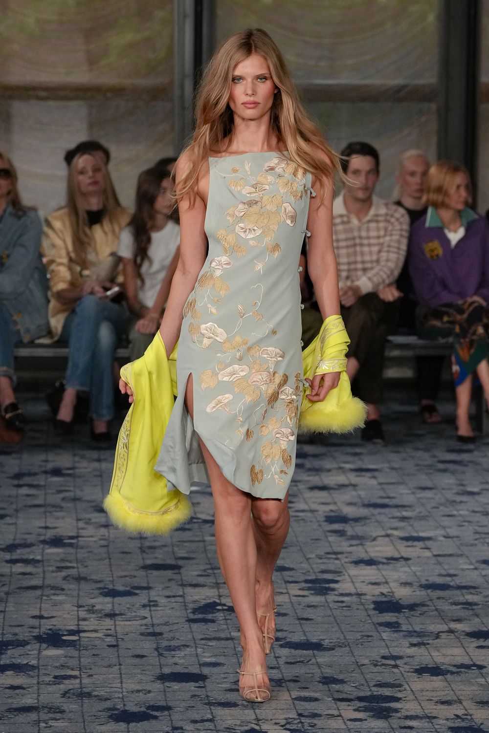 Powder-blue satin slip dress with ivory vine embroidery and frog closures. Acid yellow satin stole, marabou fluff brushing both ends. Barely there nude sandals with slim crossover straps. Garden wedding reception after midnight, carrying your wrap back from the lawn.