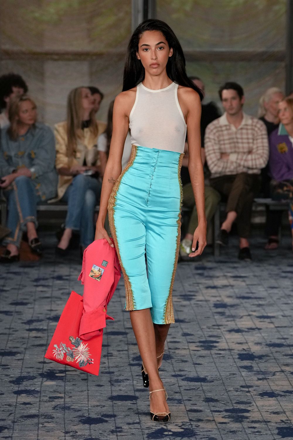 Sheer white tank with a high crew neck and raw translucence. Turquoise satin capris, ruched up the front with gold braided side seams. Hot-pink coat carried loose, one patch and floral embroidery near the hem. Cream slingbacks with black patent cap toes. For crossing the hotel lobby still carrying yesterday's party clothes.