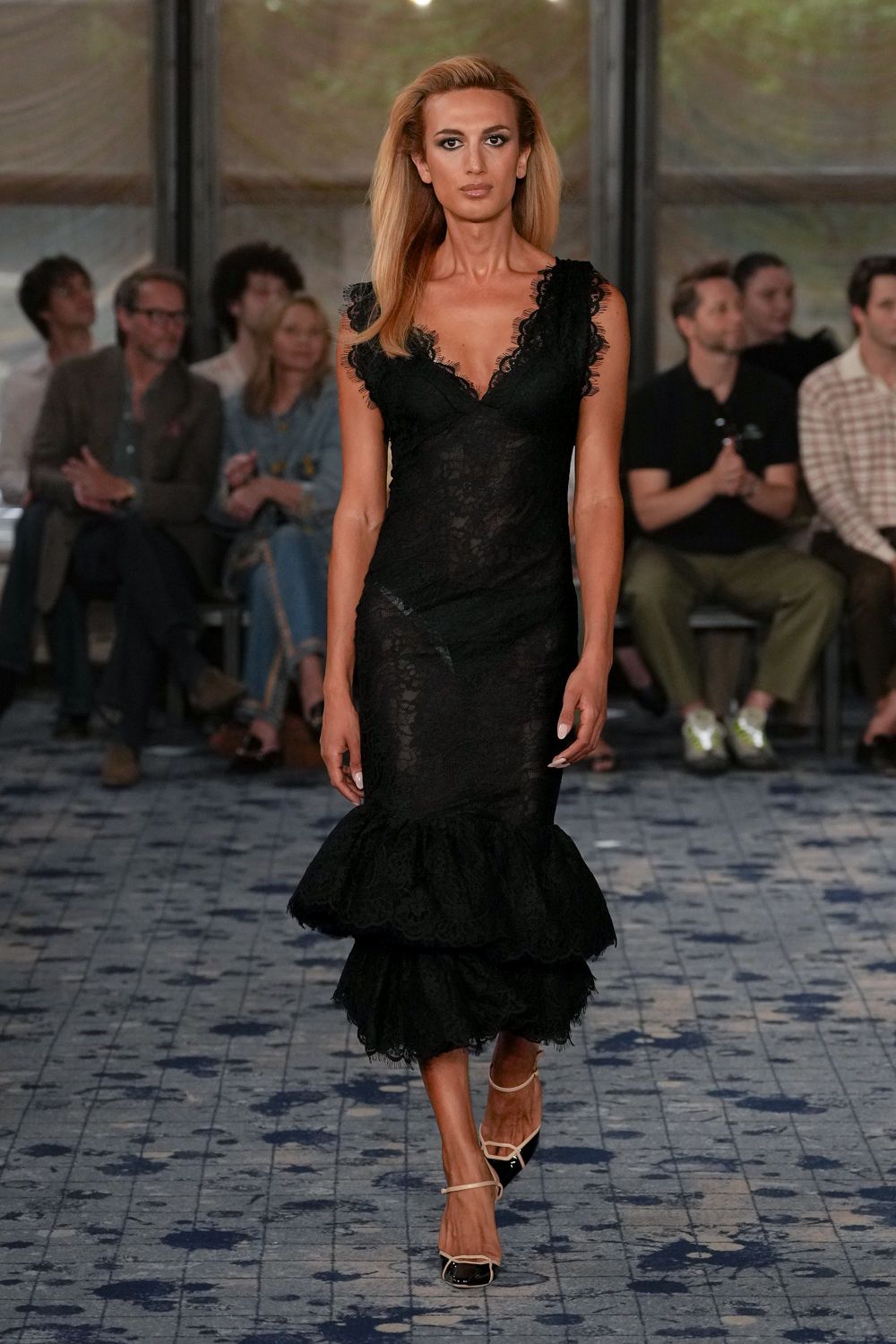 Black lace column dress with eyelash-trimmed V neckline and double flounce hem. Cream ankle-strap slingbacks with black patent cap toes. For slipping into a seaside wedding after the sun has dropped.
