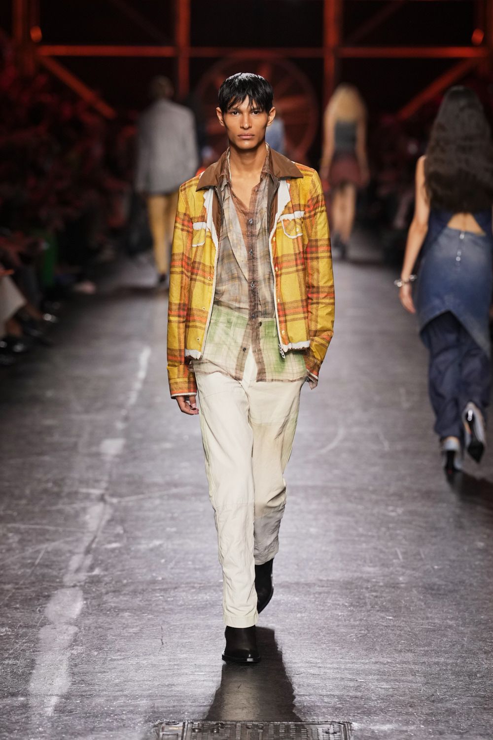 Sun-faded yellow plaid jacket with white piped flap pockets and raw hems. Sheer brown plaid shirt hanging open, washed to green at the lower front. Off-white trousers with a wrinkled finish and dusty olive shading at the thighs. Black square-toe ankle boots. Walking back from the feed store in air still warm after rain.
