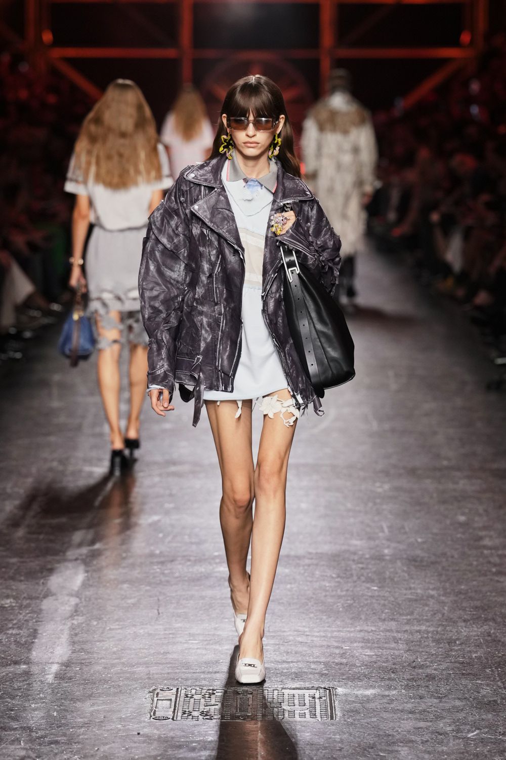Rectangular smoked visor shades. Lime squiggle drop earrings. Oversized black leather, heavily wrinkled with chalky seam topstitching. Powder blue collared mini, sheer yoke and raw hem strings. Slouchy black tote with a broad punched strap. White square-toe flats. Whatever you throw on for milk at dawn after not going home.