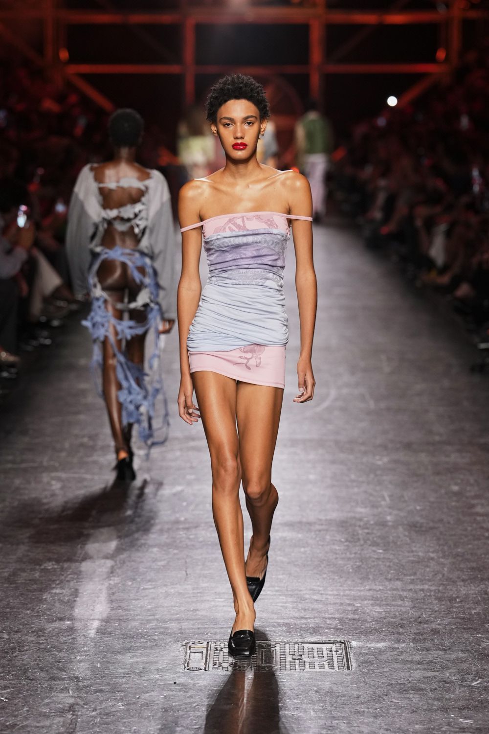 Ruched powder-blue mesh tube dress over a pink printed underlayer. Black square-toe pumps with a loafer-like vamp. Walking home after dawn, lipstick intact and last night's flyer in your pocket.